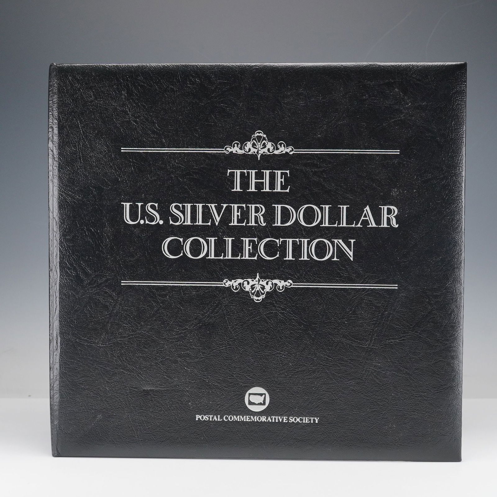 1878-1935 PCS U.S. Silver Dollar Collection, 26 Morgan & 9 Peace: A comprehensive Postal Commemorative Society U.S. Silver Dollar Collection containing a total of 35 coins, including 26 Morgan Dollars (1878-1921) and 9 Peace Dollars (1922-1935). Each coin is present
