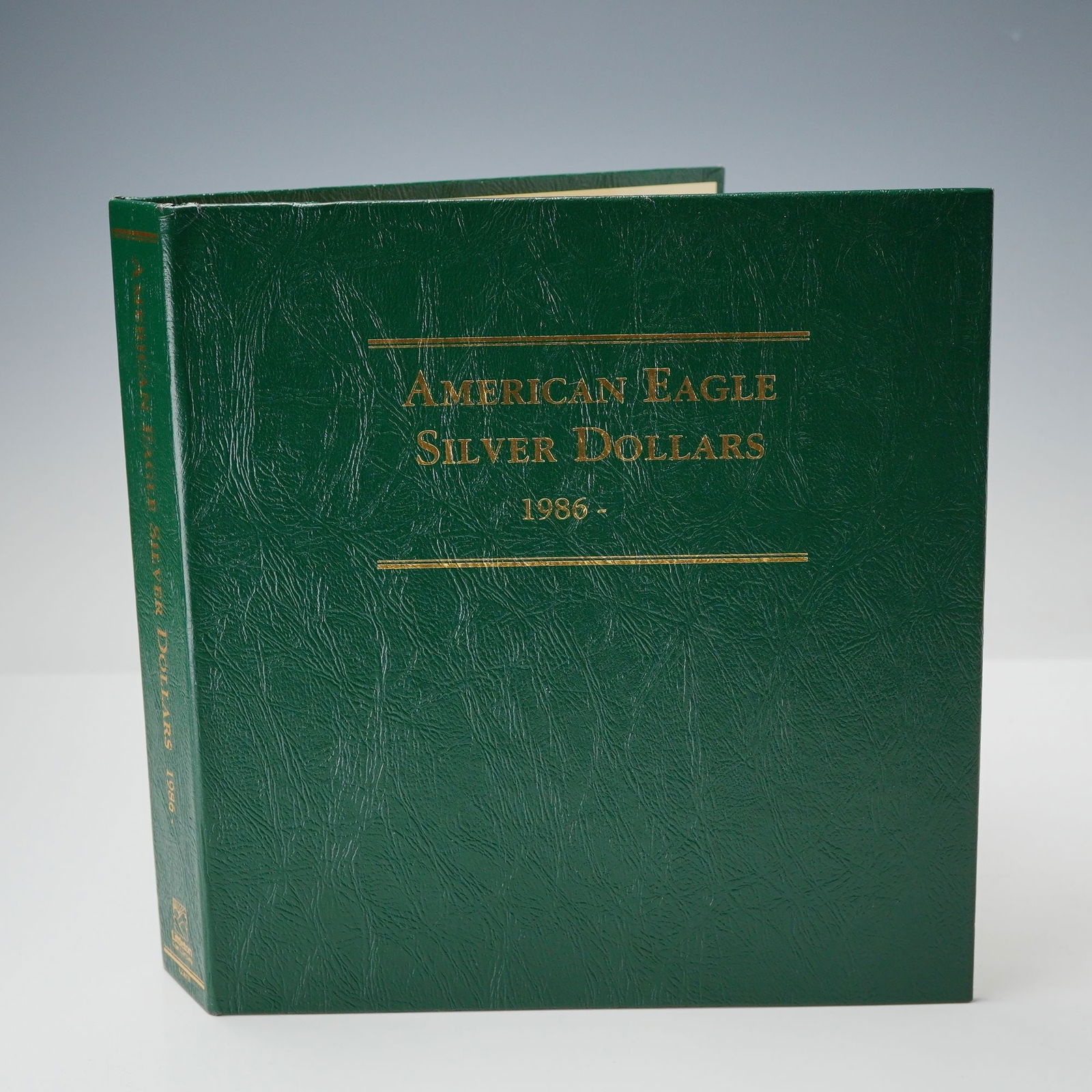 1986- 2003 American Eagle Silver Dollar Uncirculated Coins: A complete 18-coin set spanning 1986 through 2003, presented in a green Library of Coins album marked American Eagle Silver Dollars 1986-. Each coin contains 1 troy ounce of .999 fine silver and featu
