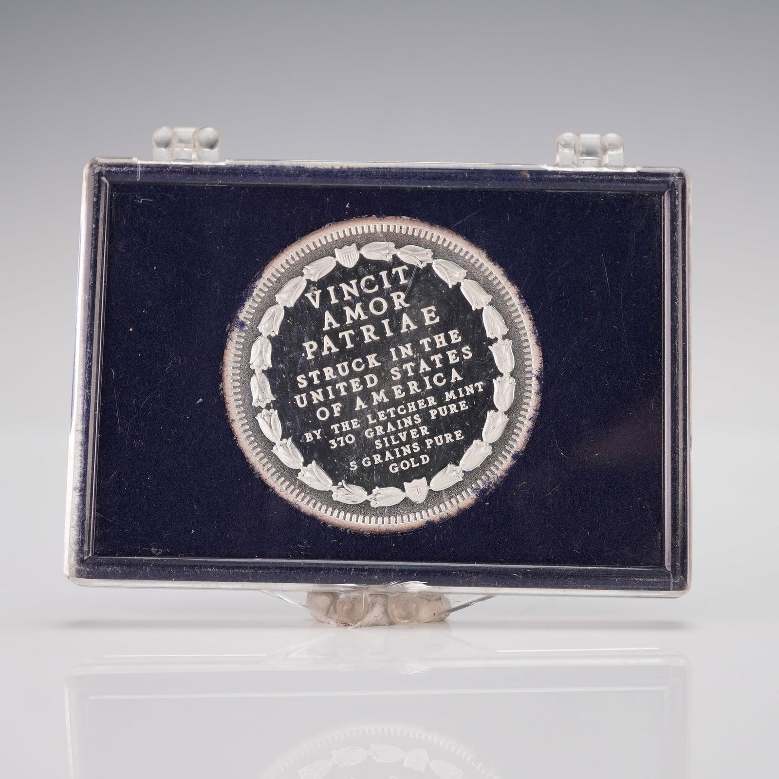 1976-L John Hancock American Patriots Silver and Gold Bullion: Featuring an obverse portrait of John Hancock highlighted in gold tone, framed by stars, a quill, and a document, with inscriptions AMERICAN PATRIOTS, JOHN HANCOCK, 1776, and 1976, while the reverse d