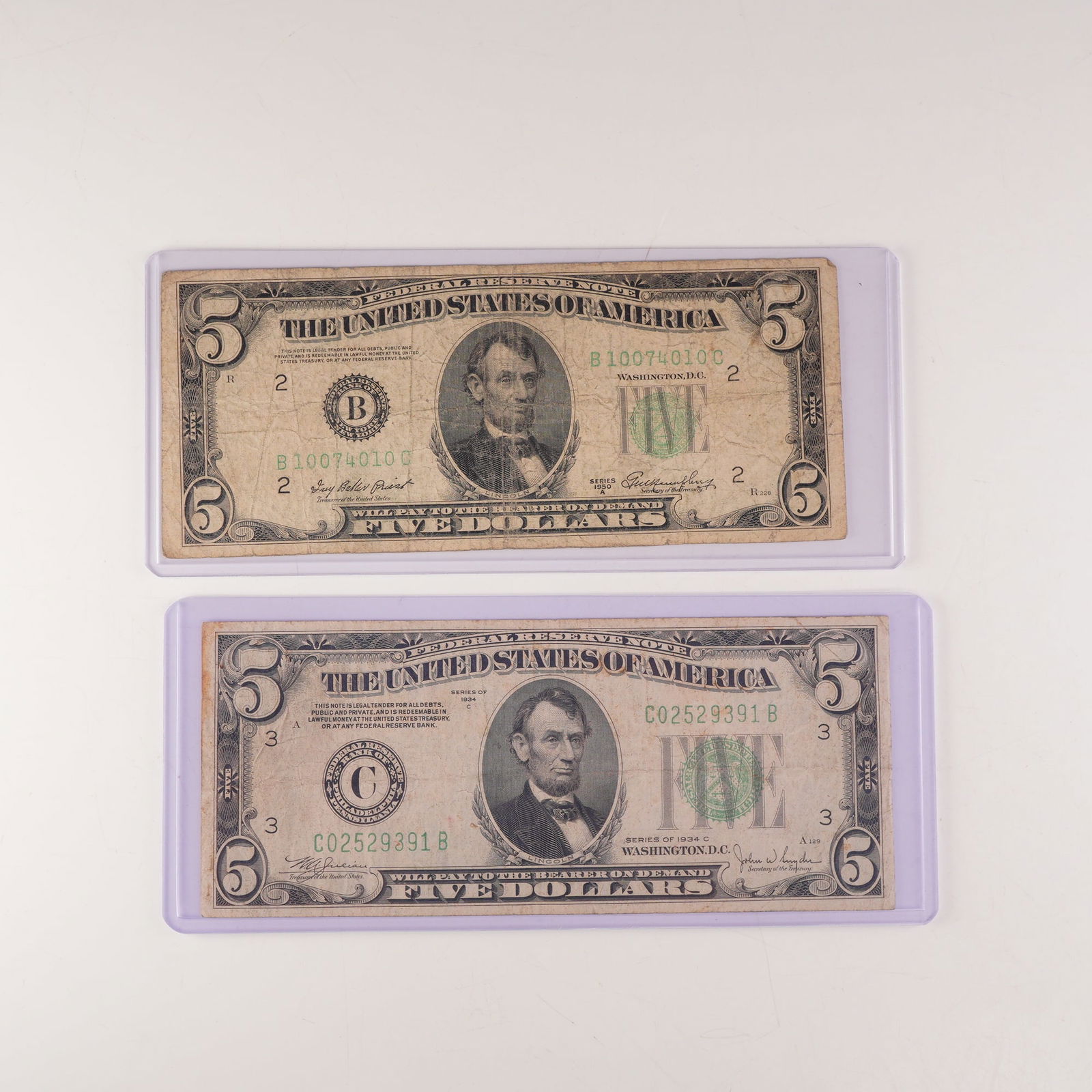 2pc 1934C, 1950A U.S Federal Reserve Five Dollar Notes: U.S. Federal Reserve $5 notes, series 1934C and 1950A. Both feature the portrait of President Abraham Lincoln at center with the green Treasury seal and serial numbers to the right. The reverse depict