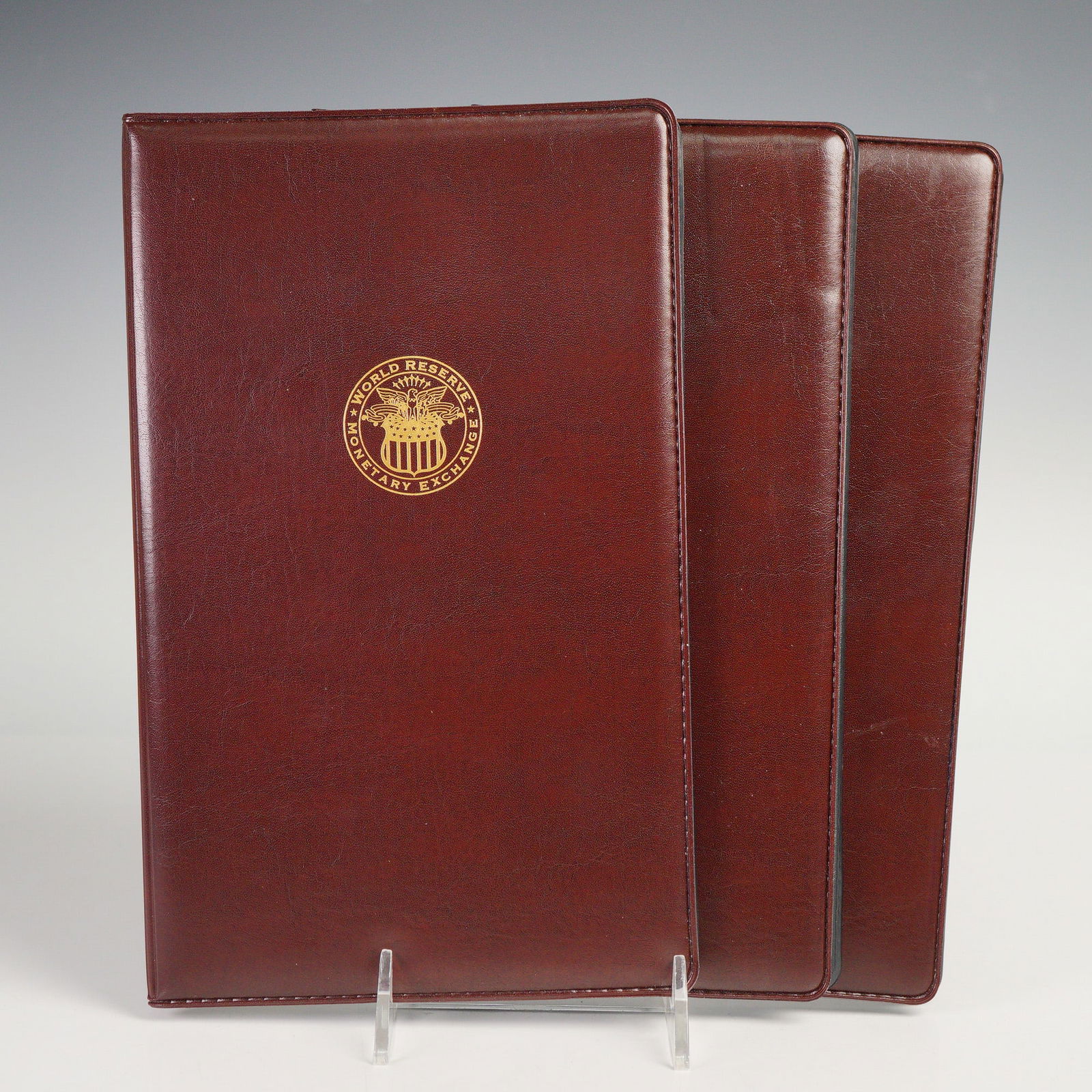 3pc 2009 U.S. Federal Reserve One Dollar Uncut Notes: U.S. Federal Reserve uncut one-dollar note sheets, each preserved in an official World Reserve Monetary Exchange presentation folder. Each folder includes an Official Certificate of Ownership