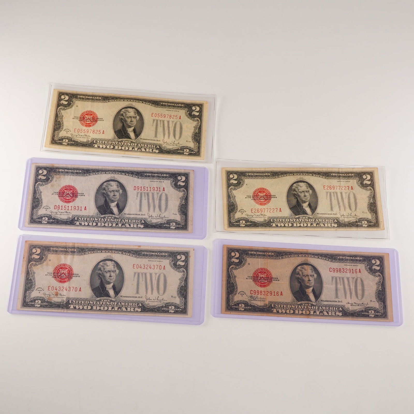 5pc 1928 D,G U.S. Two Dollar Red Seal Notes: 1928 U.S. $2 Red Seal Legal Tender Notes, comprising one Series D and four Series G examples. Each note displays the portrait of Thomas Jefferson at center with red Treasury seal and serial numbers, i