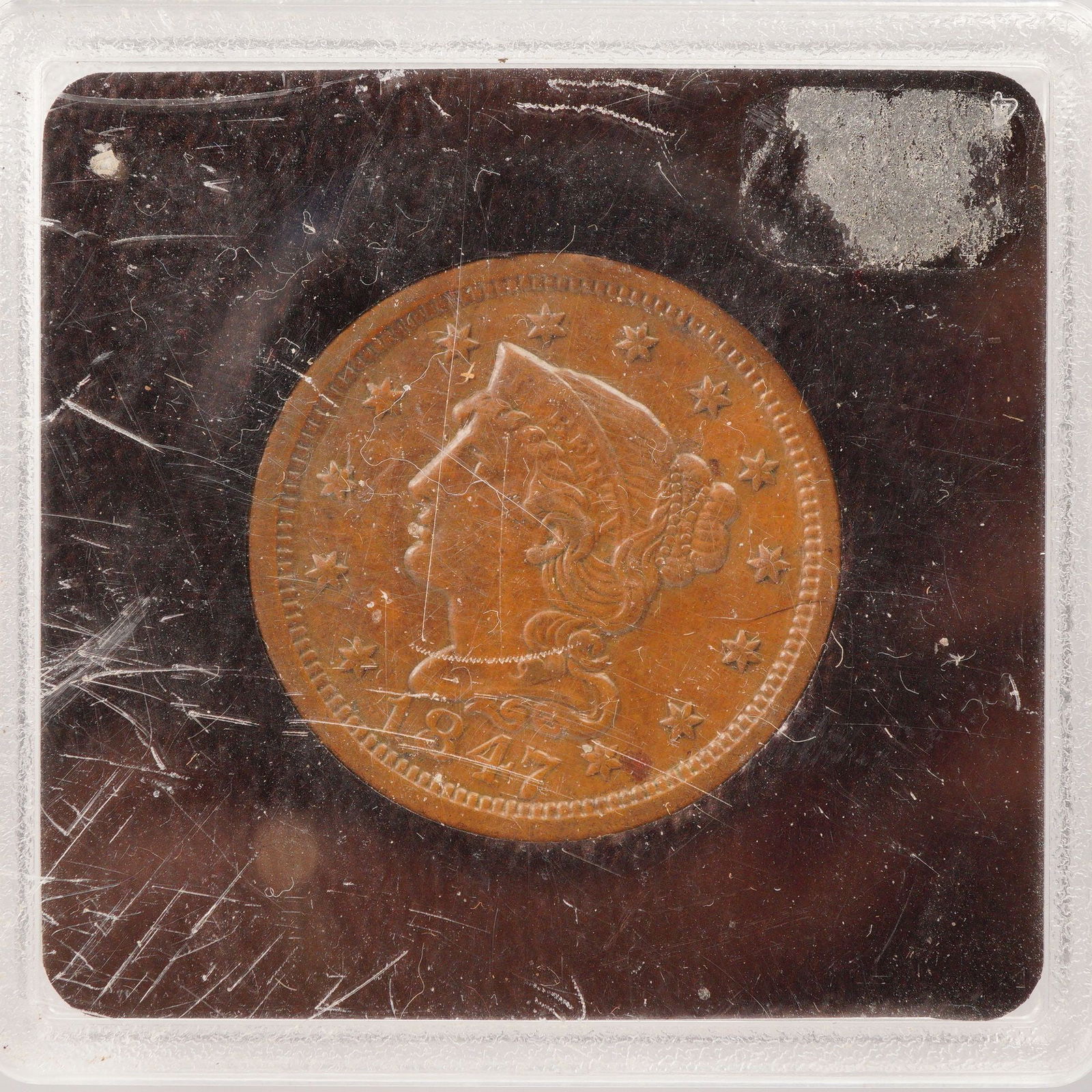 1847 Liberty Braided Hair One Cent Coin: The obverse portrait of Liberty wearing a coronet inscribed with her name, encircled by thirteen stars, and the year below. The reverse bears a wreath surrounding the denomination ONE CENT. Composed o