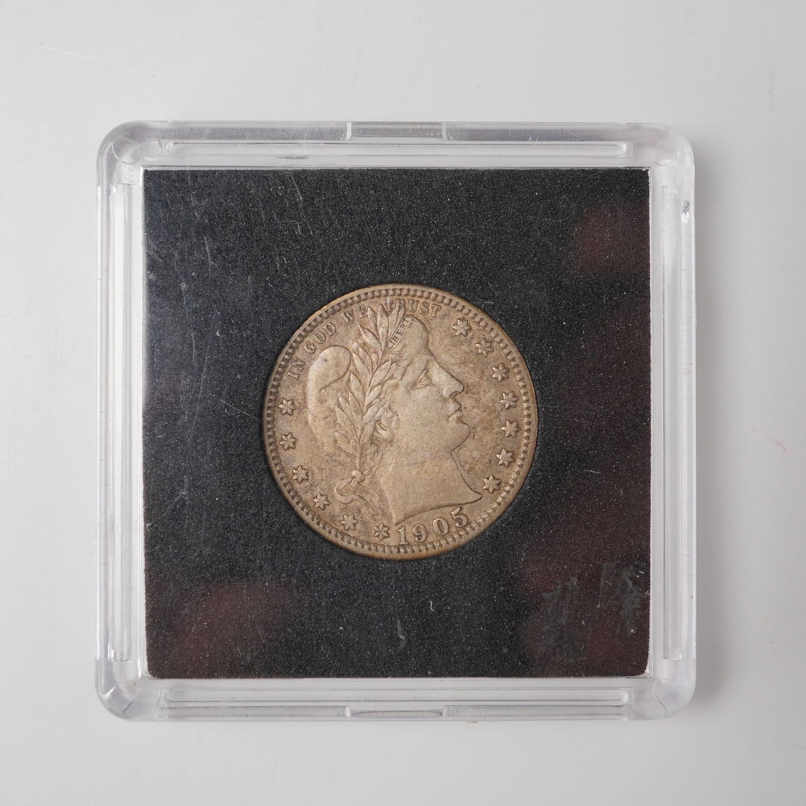 1905 Barber Quarter Dollar Coin: Composed of .900 silver, the obverse depicts the classical profile of Liberty crowned with a laurel wreath, encircled by thirteen stars and the national motto, with the date prominently placed below.
