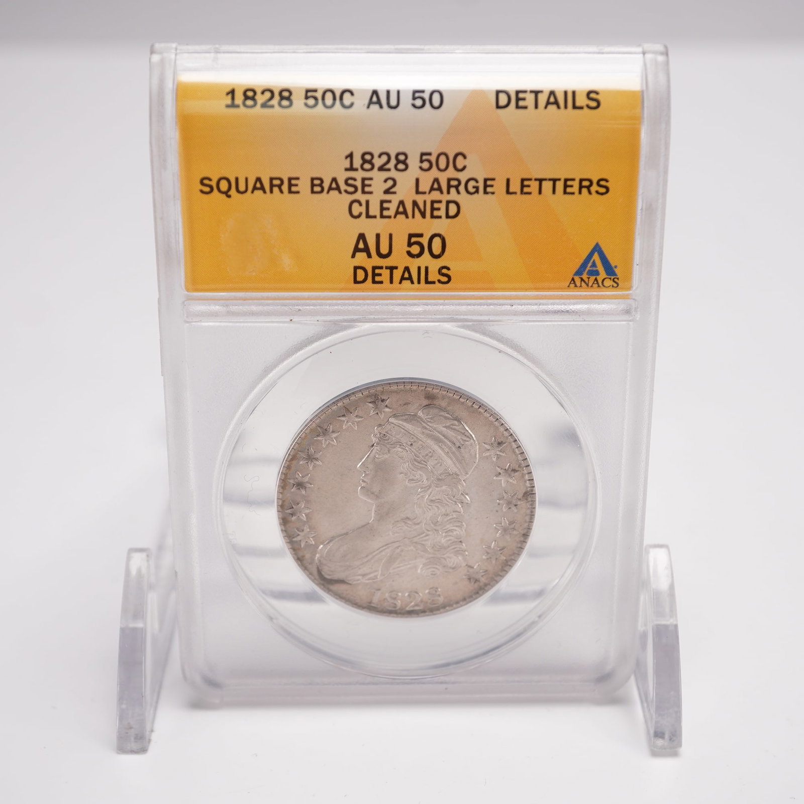 1828 Capped Bust Half Dollar ANACS Graded AU 50 Square Base 2: ANACS certified AU 50 Details, variety with Square Base 2 and Large Letters, noted as cleaned. The obverse features Liberty facing left, wearing a Phrygian cap with the word LIBERTY inscribed on the b