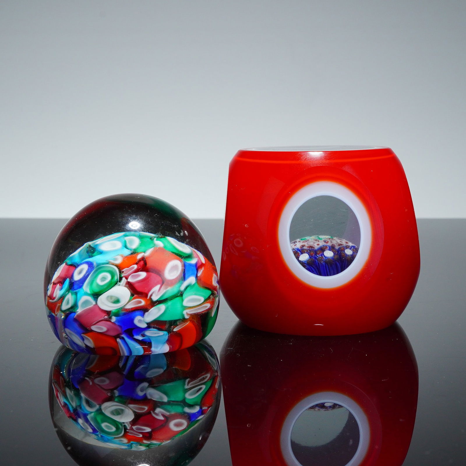 2pc Art Glass Paperweights: Lively pair of contemporary art glass paperweights featuring bold color, sculptural form, and striking internal decoration. The first example is a rounded dome paperweight with a clear outer casing