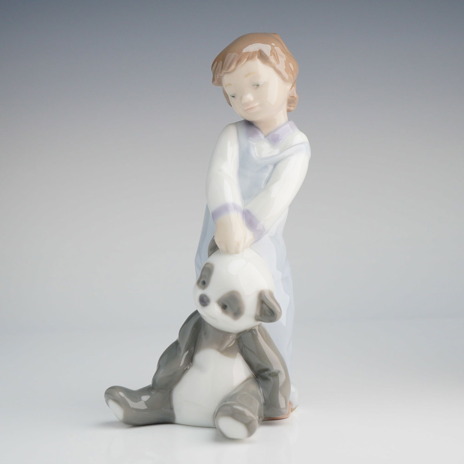 Lladro Porcelain Figurine First Discoveries 6974: A lot of two items comprising the Lladro glazed porcelain figurine titled First Discoveries, model number 6974 (also listed as 1006974), and its original retail packaging. The figurine depicts a young
