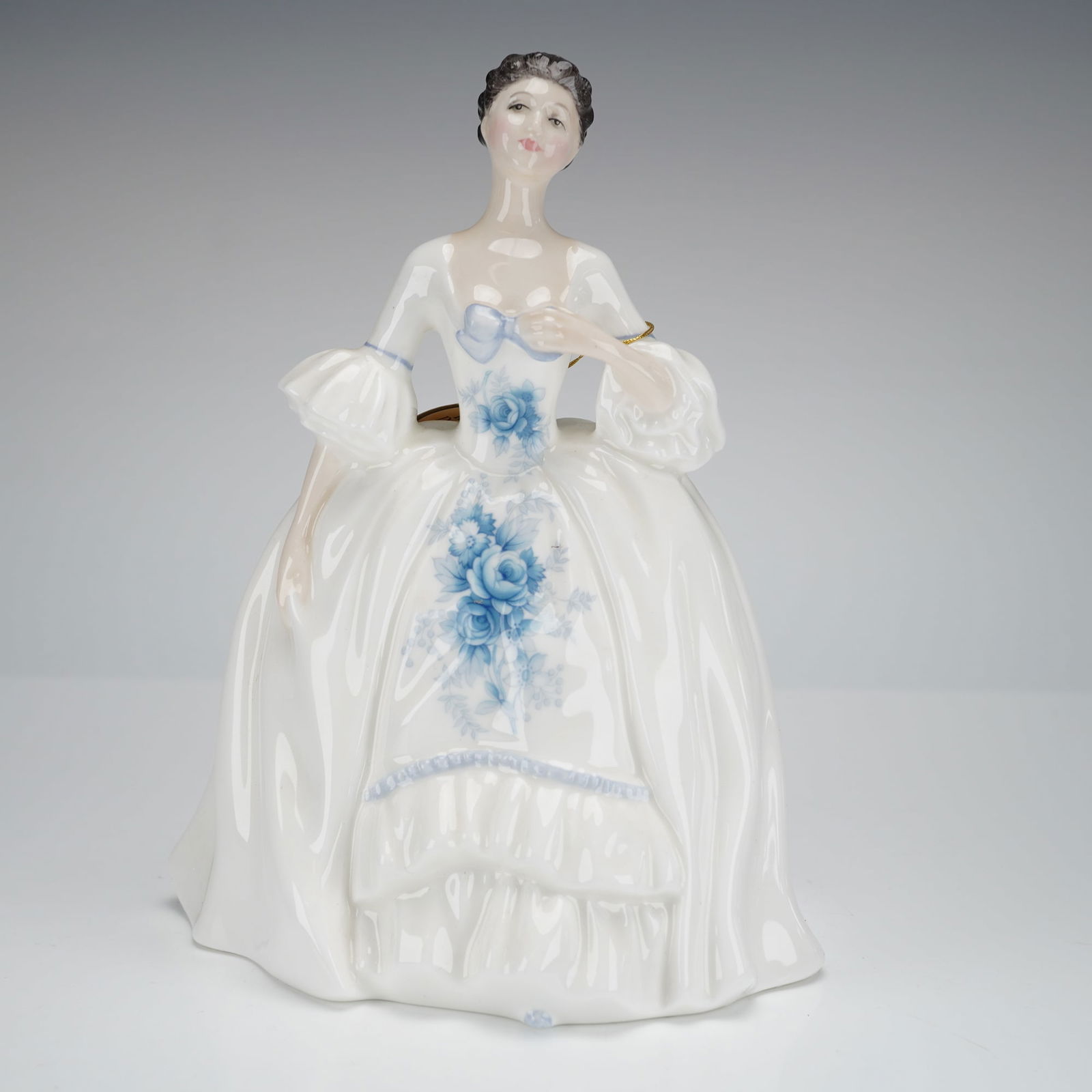 Royal Doulton Porcelain Figurine Kelly HN2478: A single glazed porcelain figurine titled Kelly, model number HN2478, produced by Royal Doulton. The piece was modeled by Peggy Davies and is dated 1984. The female figure is depicted standing in a vo
