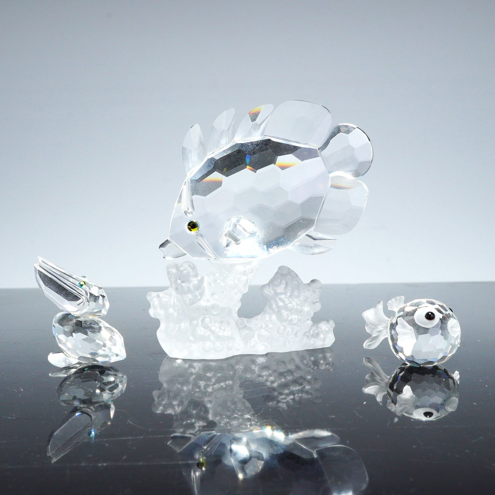 3pc Swarovski Crystal Figurines Butterfly Fish, Pelican, and Mini Blowfish: A trio of Swarovski Silver Crystal figurines featuring aquatic and avian subjects. The collection includes a retired Butterfly Fish on Reef figurine, designed with a multi-faceted clear crystal body a