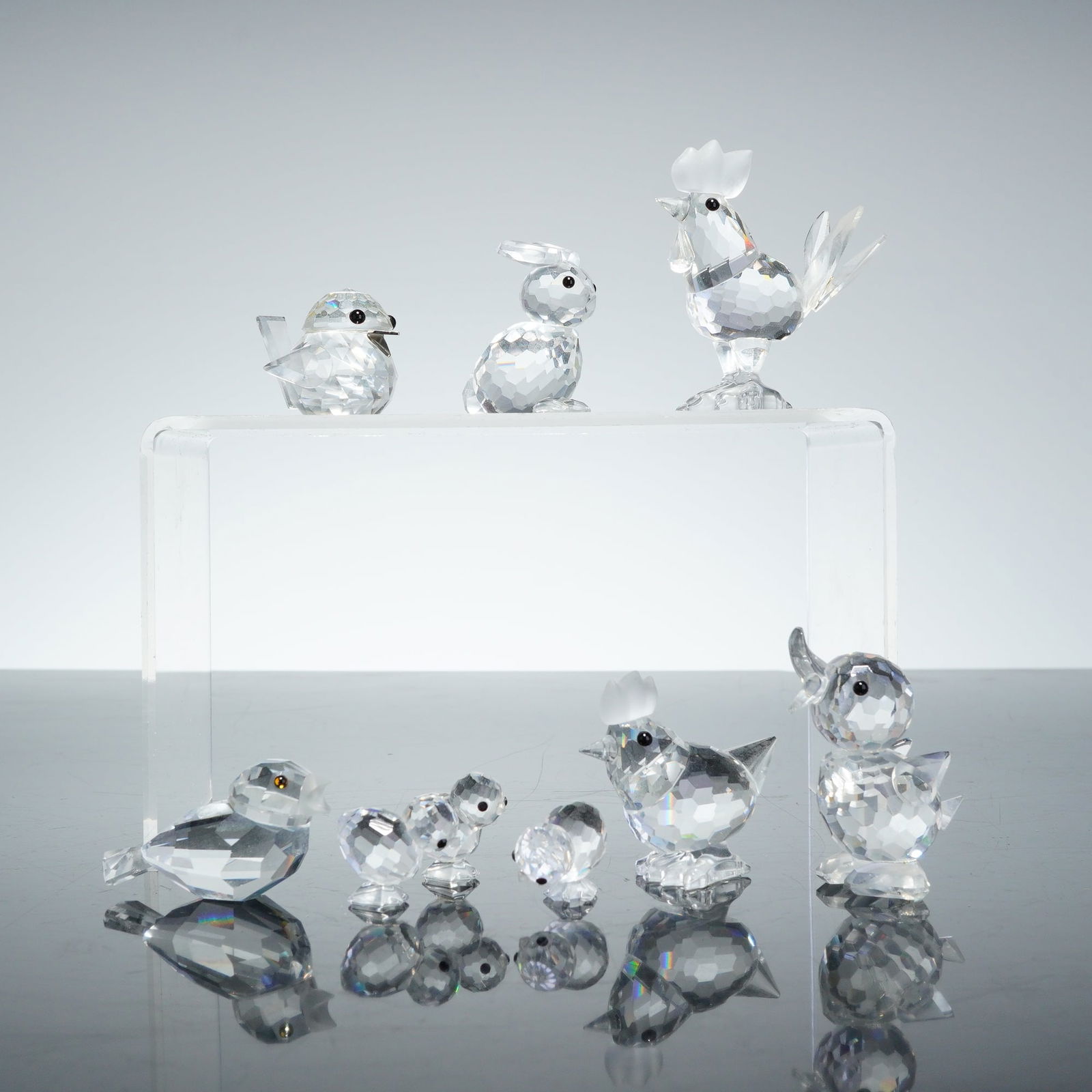 9pc Swarovski Crystal Miniature Figurines: A 9pc collection of Swarovski crystal miniature figurines featuring a variety of avian and mammalian subjects. This set includes a rooster, a hen, three chickens, a bunny, a sparrow, a duck, and an ad