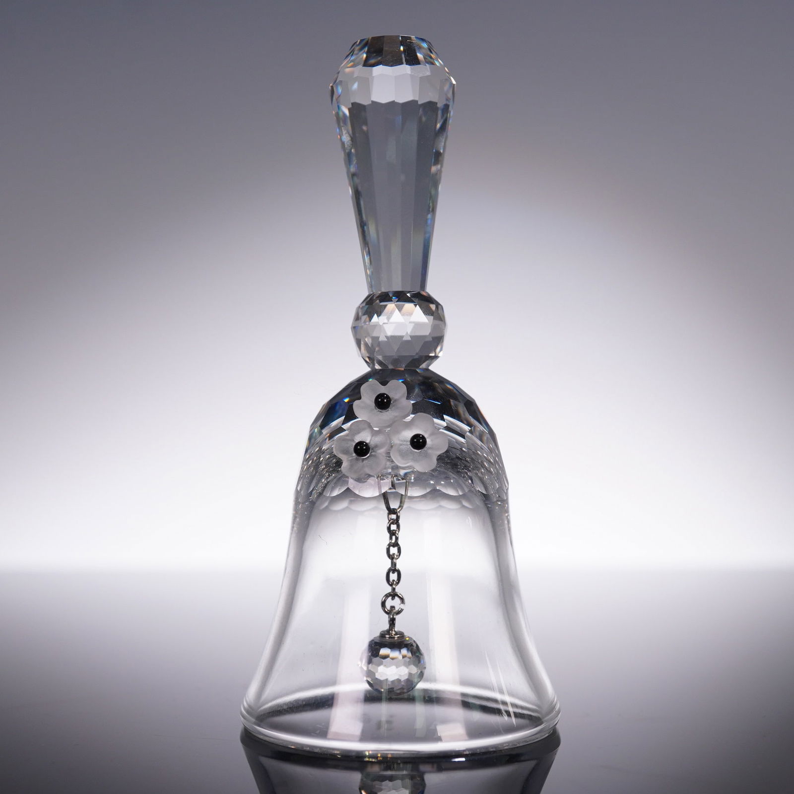 Swarovski Crystal Small Table Bell: Swarovski Silver Crystal table bell designed by Max Schreck. This elegant bell features a faceted handle, frosted floral applique, and a faceted clapper suspended on a chain. Stands approximately 3.5