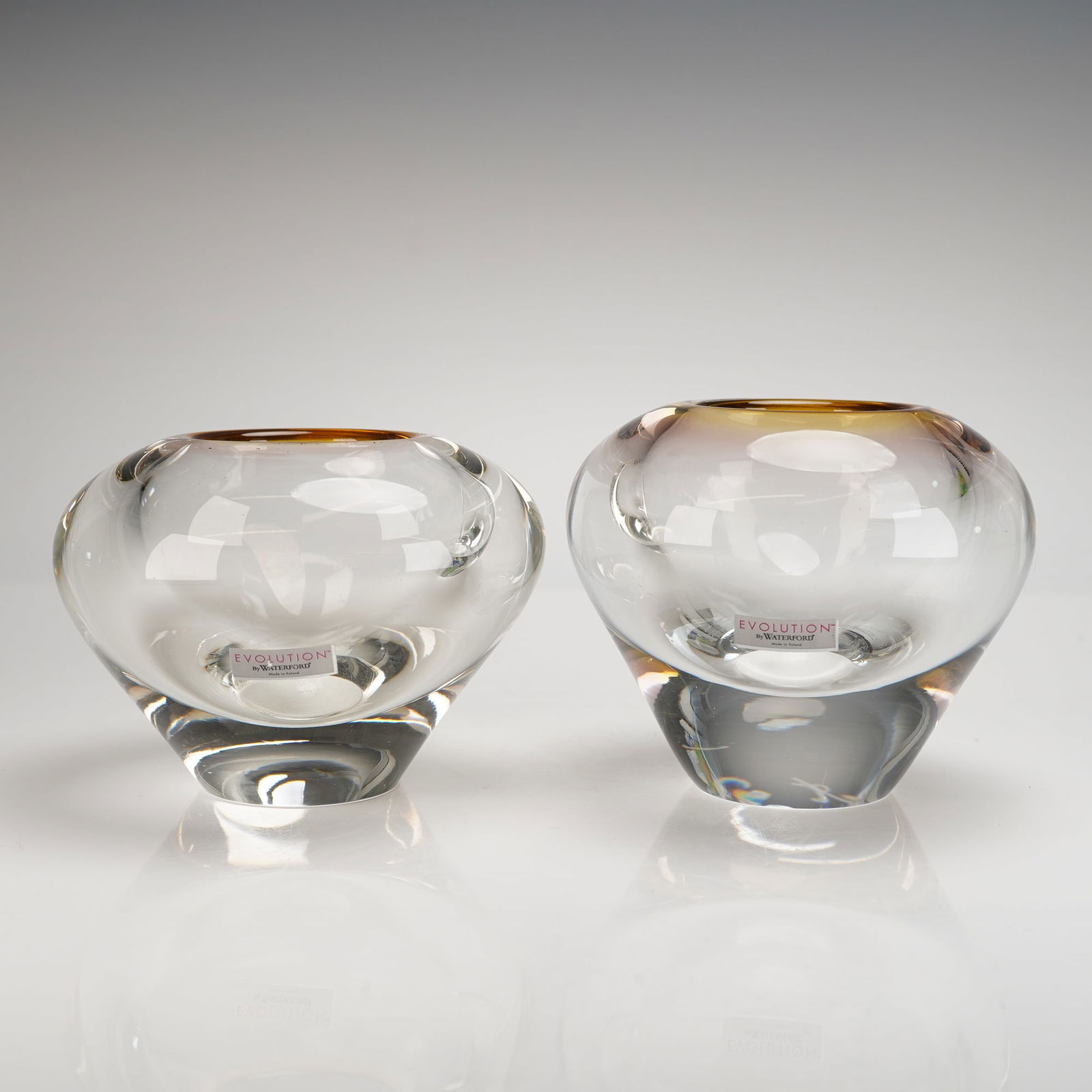 2pc Vincent Rellis Evolution by Waterford Crystal Votives: Modern art glass votives, executed in thick, heavy crystal. These pieces are by Vincent Rellis for the Evolution by Waterford line. Each vessel features a globular form resting on a heavy, faceted bas