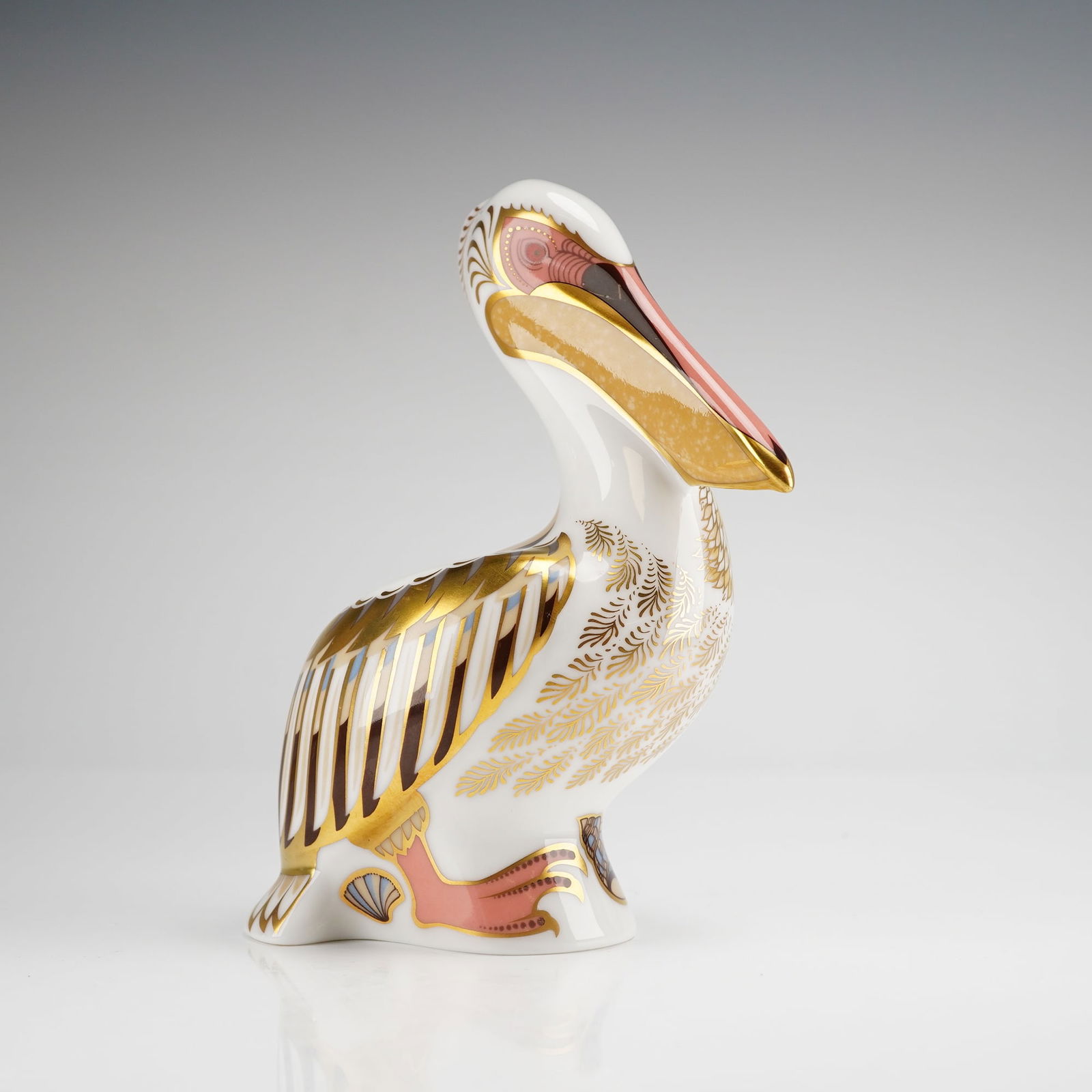 Royal Crown Derby White Pelican Limited Edition Figurine: A Royal Crown Derby fine bone china paperweight titled White Pelican. This piece is a limited edition, numbered 1013 of 5000. The figurine is decorated with 22kt gold gilding and features feather patt