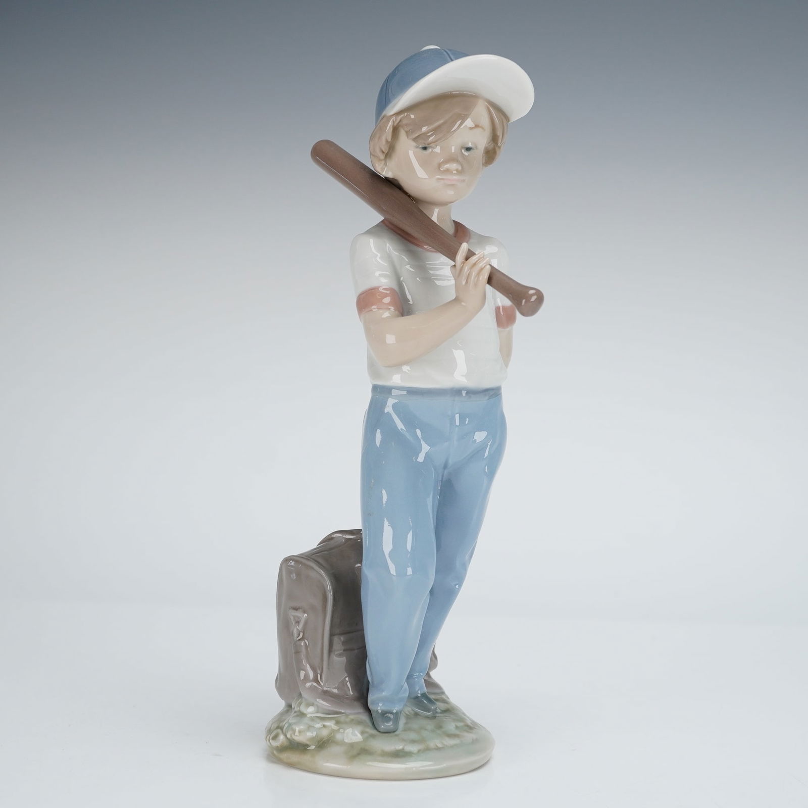 Lladro Porcelain Figurine Can I Play Model 7610: A Lladro Porcelain Figurine, model number 7610, titled "Can I Play". The lot includes the figurine and its original presentation box. The glazed porcelain figure depicts a young boy dressed in a white