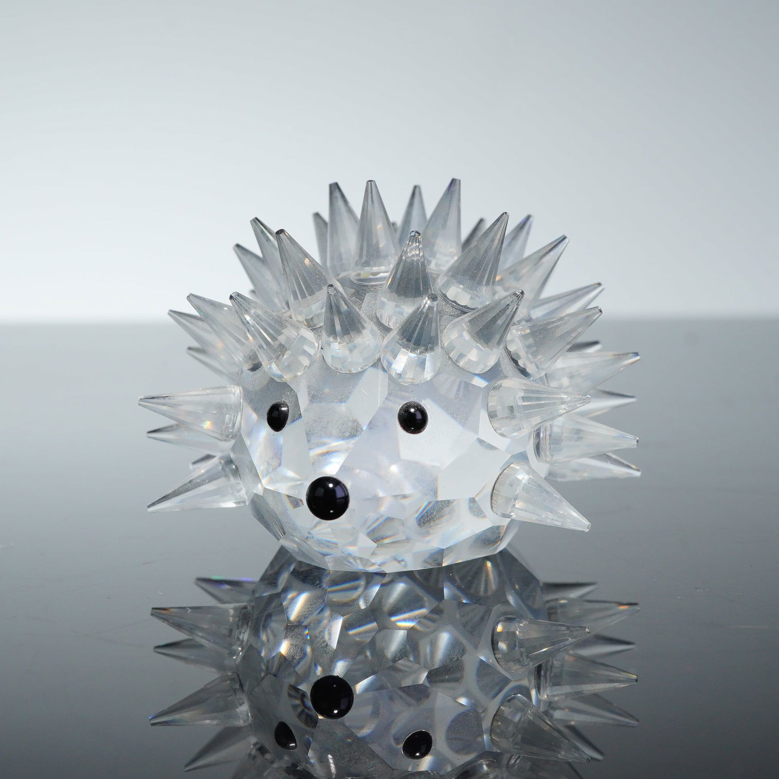 Swarovski Crystal Figurine Hedgehog Porcupine: A Swarovski Crystal Figurine depicting a hedgehog, also commonly identified as a porcupine. The piece is crafted from faceted lead crystal with a rounded body and numerous pointed crystal quills. Thre