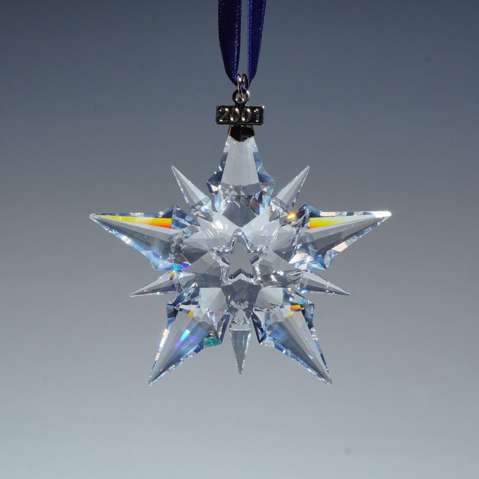 Swarovski Crystal 2001 Annual Edition Christmas Ornament, 267941: This Annual Edition Christmas ornament is a multi-faceted crystal star. The piece includes a silver-tone metal tag at the top marked 2001 and features the etched Swarovski swan logo on one facet. It