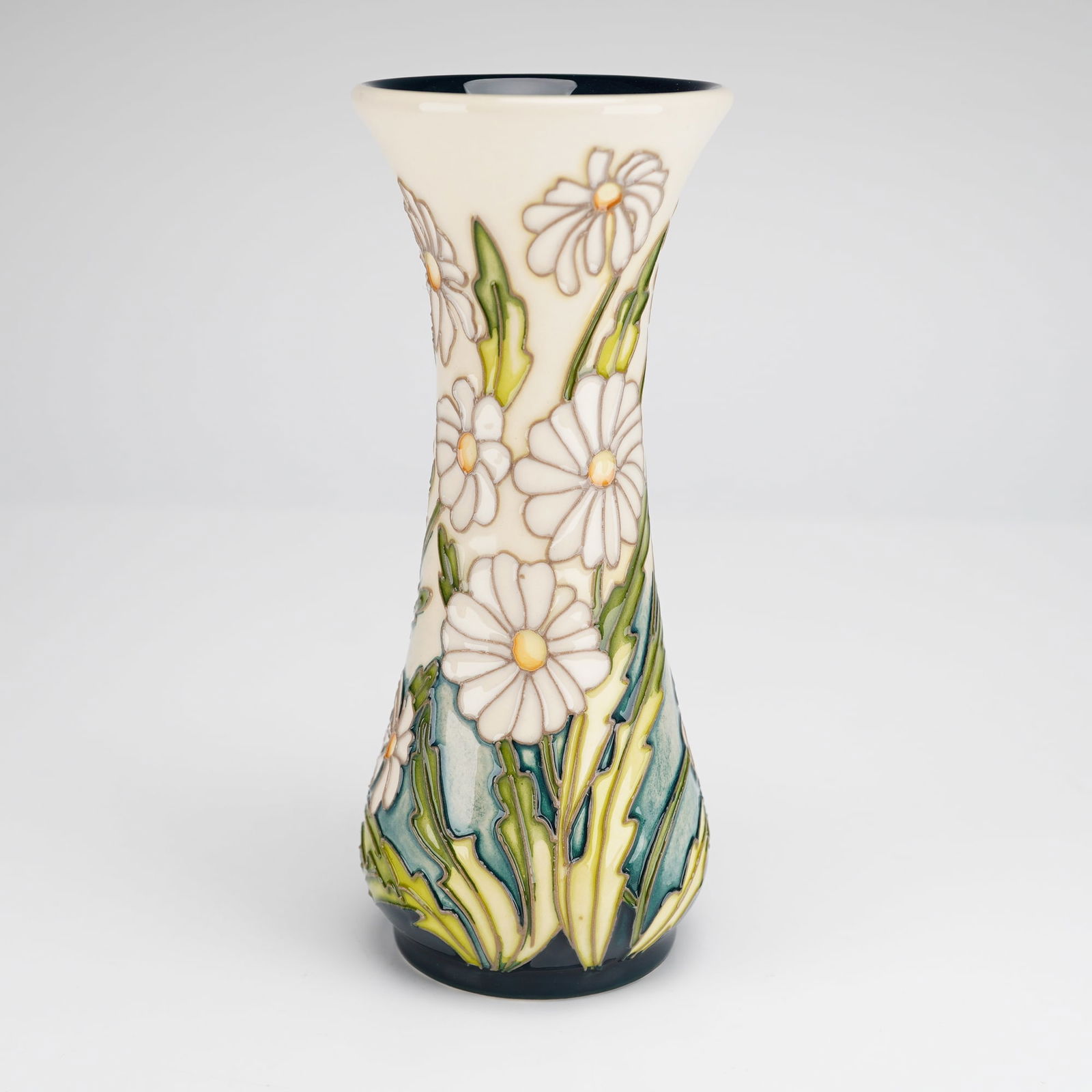 A Modern Moorcroft Pottery April's Innocence Pattern Vase: A modern Moorcroft pottery ceramic vase of waisted form in the April's Innocence pattern. The exterior features a tube-lined floral motif of white daisies with yellow centers and green foliage