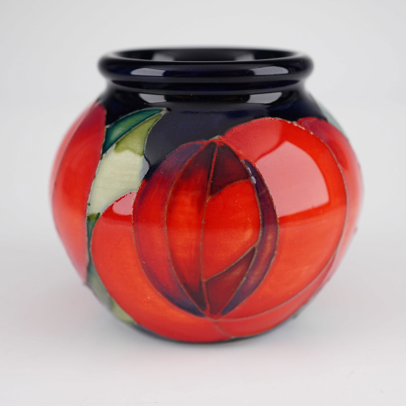 Moorcroft Red Rose Limited Edition Miniature Ceramic Vase: This lot features a Moorcroft Red Rose limited edition miniature ceramic vase. The vessel is of a squat, bulbous form and is decorated with a tubelined floral pattern in shades of red and green