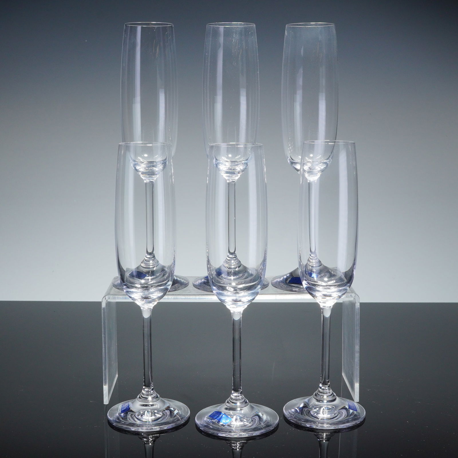 6pc Marquis by Waterford Crystal Champagne Flutes, Vintage: A set of six Marquis by Waterford crystal champagne flutes in the Vintage pattern. Each piece is crafted from clear crystal and features an elongated, tapered bowl set upon a slender stem and a circul