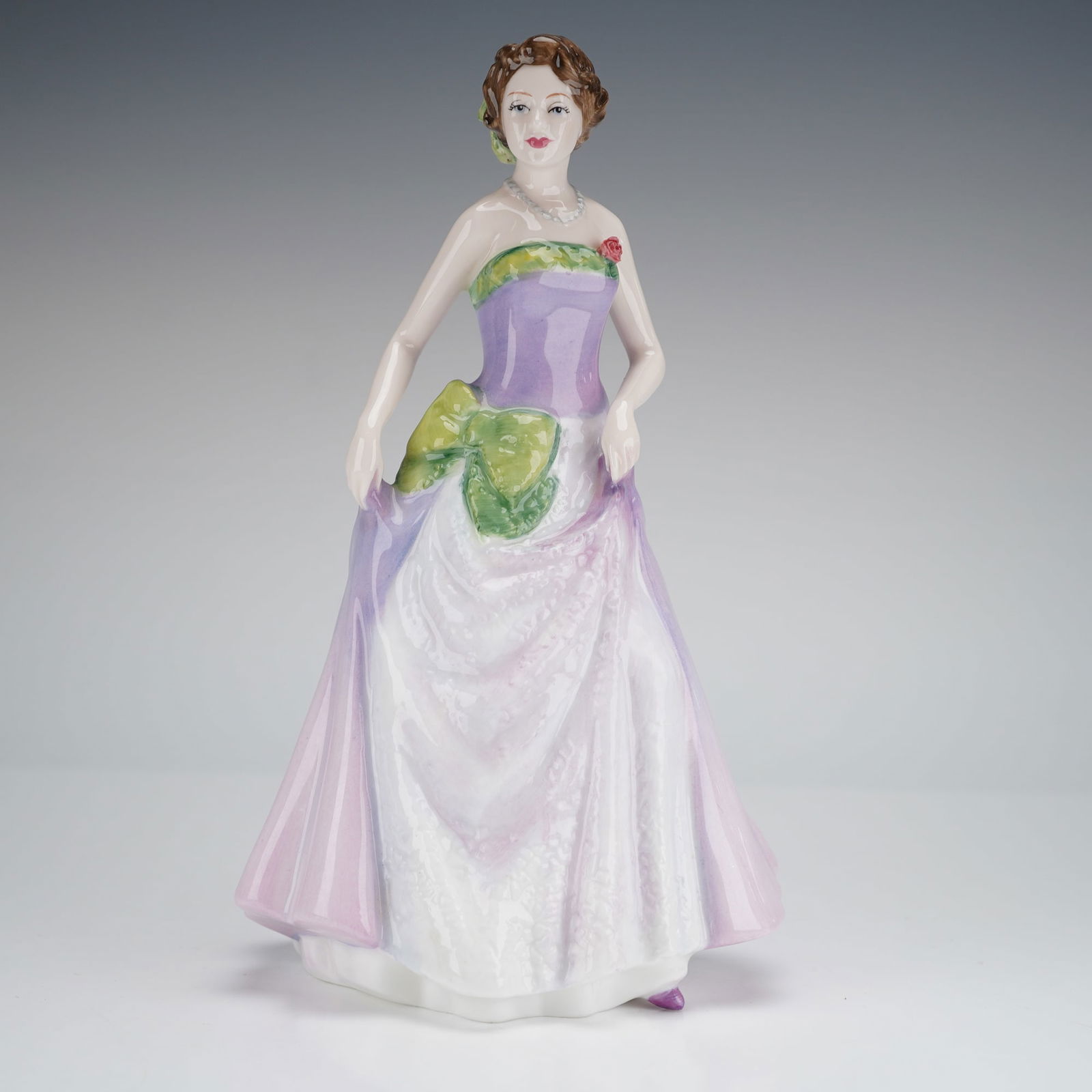 Royal Doulton Jessica HN3850 Figure of the Year 1997 Figurine: A single glazed fine china figurine by Royal Doulton, titled 'Jessica' HN 3850, designated as the Figure of the Year 1997. The piece depicts a woman modeled in a formal strapless ball gown, hand-decor