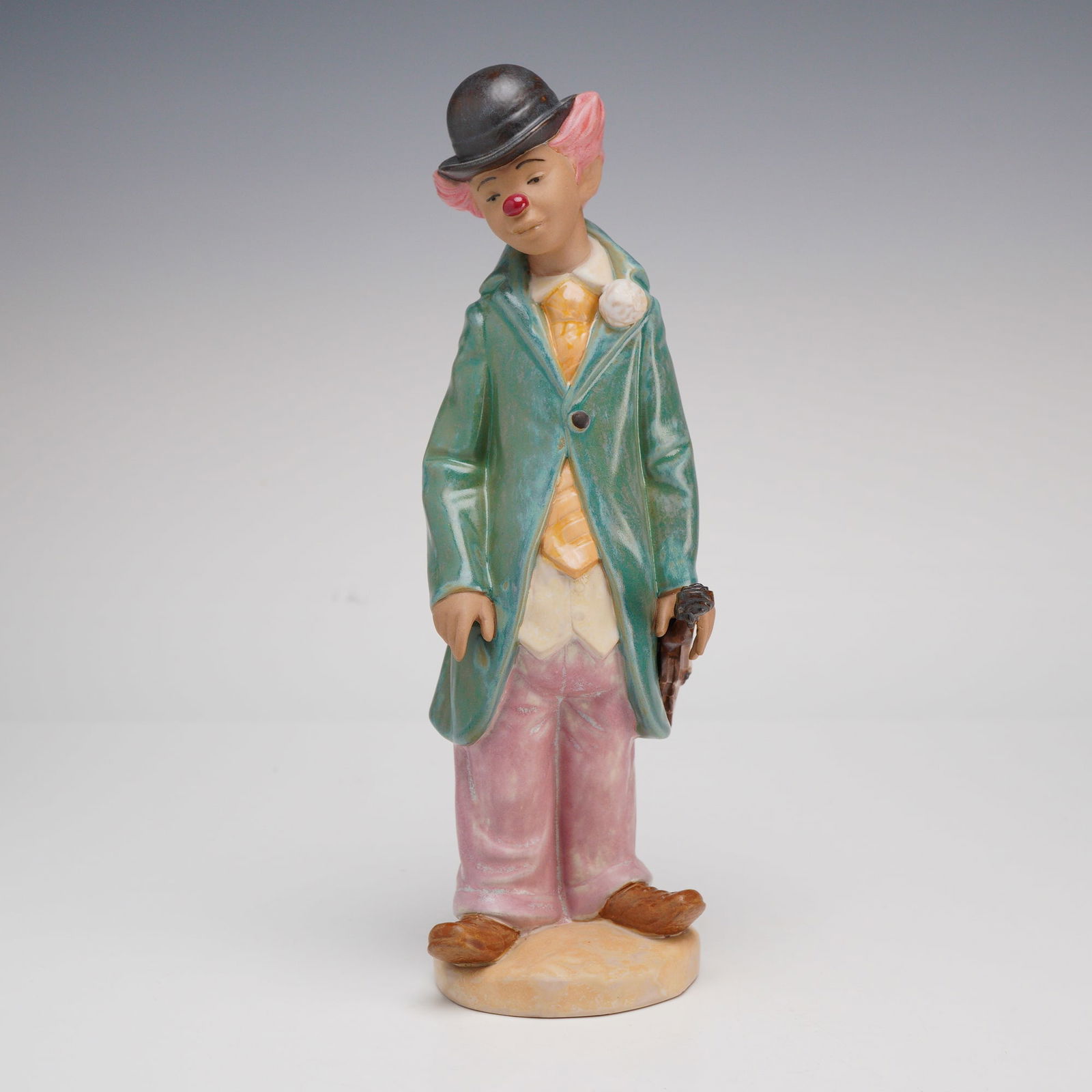Lladro, Circus Sam Clown Figurine Model 5320: A hand-painted glazed porcelain figurine produced by Lladro, titled Circus Sam and identified by model number 5320. The figure depicts a melancholic clown in a pensive stance, wearing an oversized gre