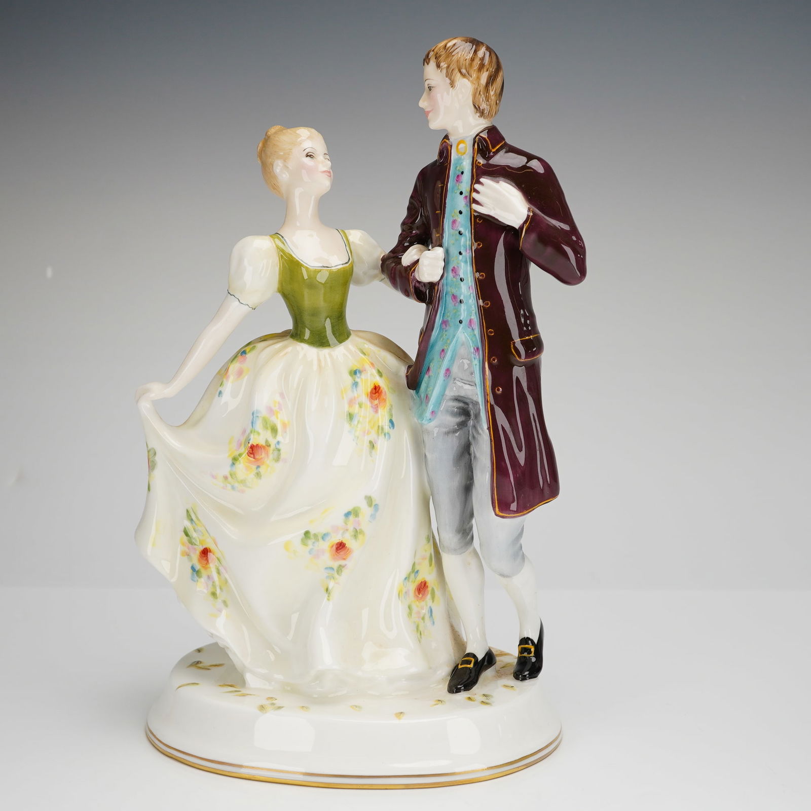 Royal Doulton Young Love HN2735 Bone China Figurine: A Royal Doulton bone china figurine titled Young Love, model number HN 2735. This piece depicts a couple in stylized 18th-century attire posed on an oval, gold-rimmed base. The female figure is modele