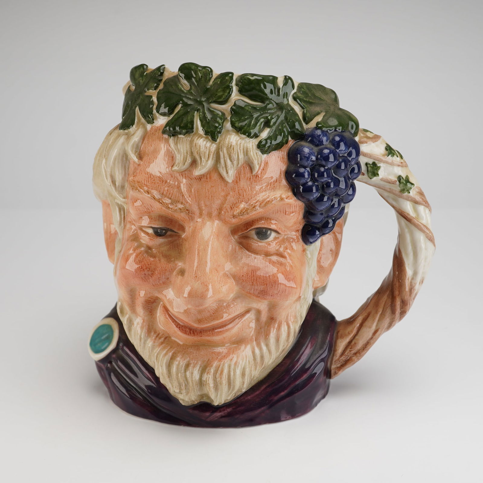 Royal Doulton Bacchus Large Character Jug D6499: A single Royal Doulton glazed earthenware character jug, identified as Bacchus, model number D6499. The jug is modeled in high-relief depicting a smiling, bearded man, polychrome decorated in shades o