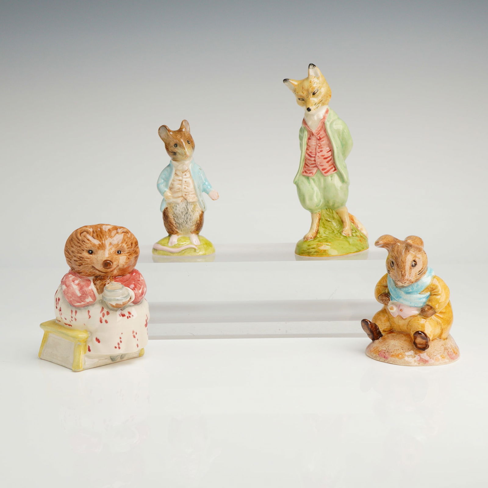Collection of Four Royal Albert Beatrix Potter Figurines: A collection of 4 ceramic Royal Albert Beatrix Potter figurines, copyrighted 1989 and made in England, featuring Johnny Town-Mouse, Mrs. Tiggy Winkle Takes Tea, Foxy Whiskered Gentleman, and Old Mr. B