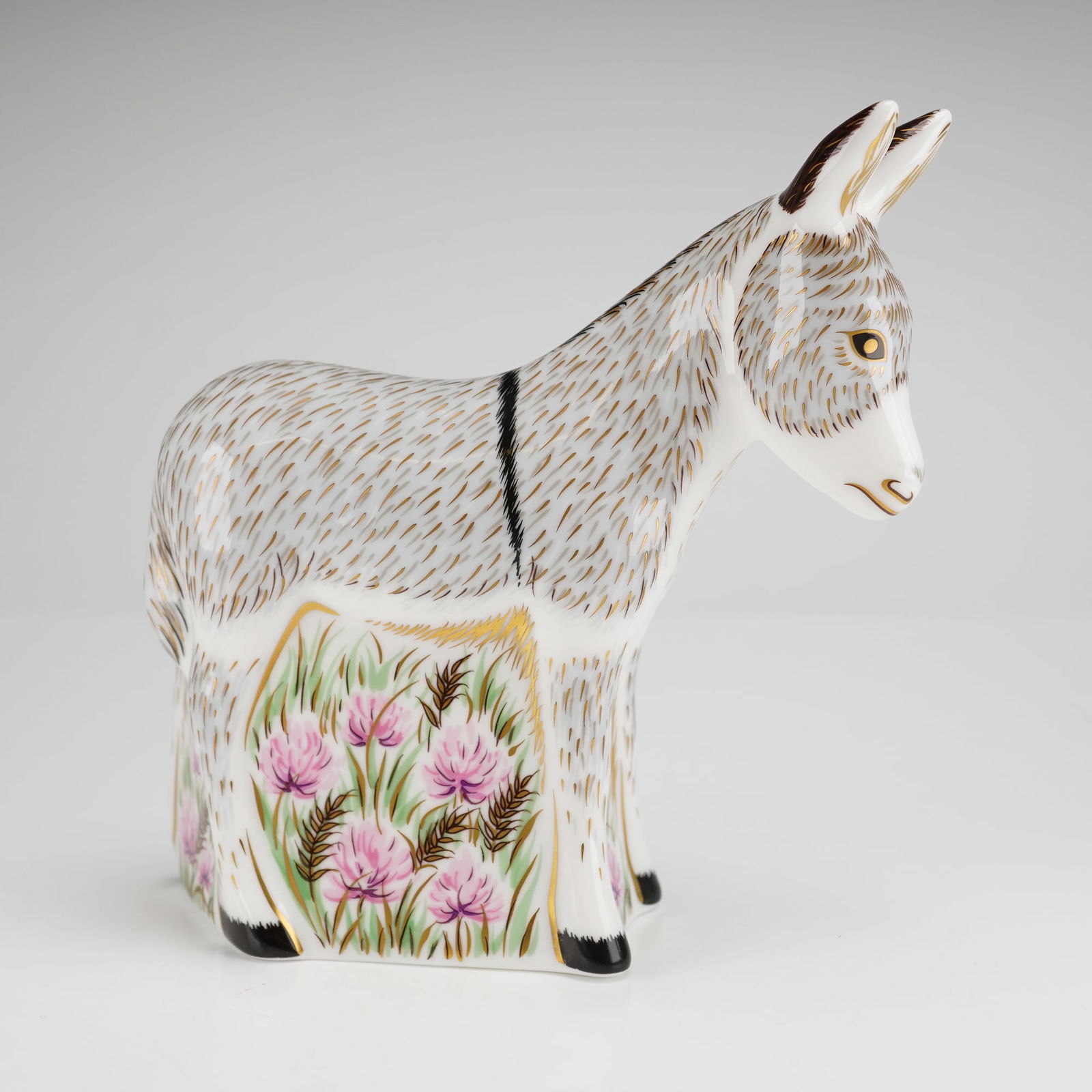 Royal Crown Derby Donkey Foal Bone China Paperweight: A Royal Crown Derby fine bone china paperweight modeled as a donkey foal, produced in England and dated 2014. The figurine is decorated with a white ground and grey and gold-accented fur patterning, f