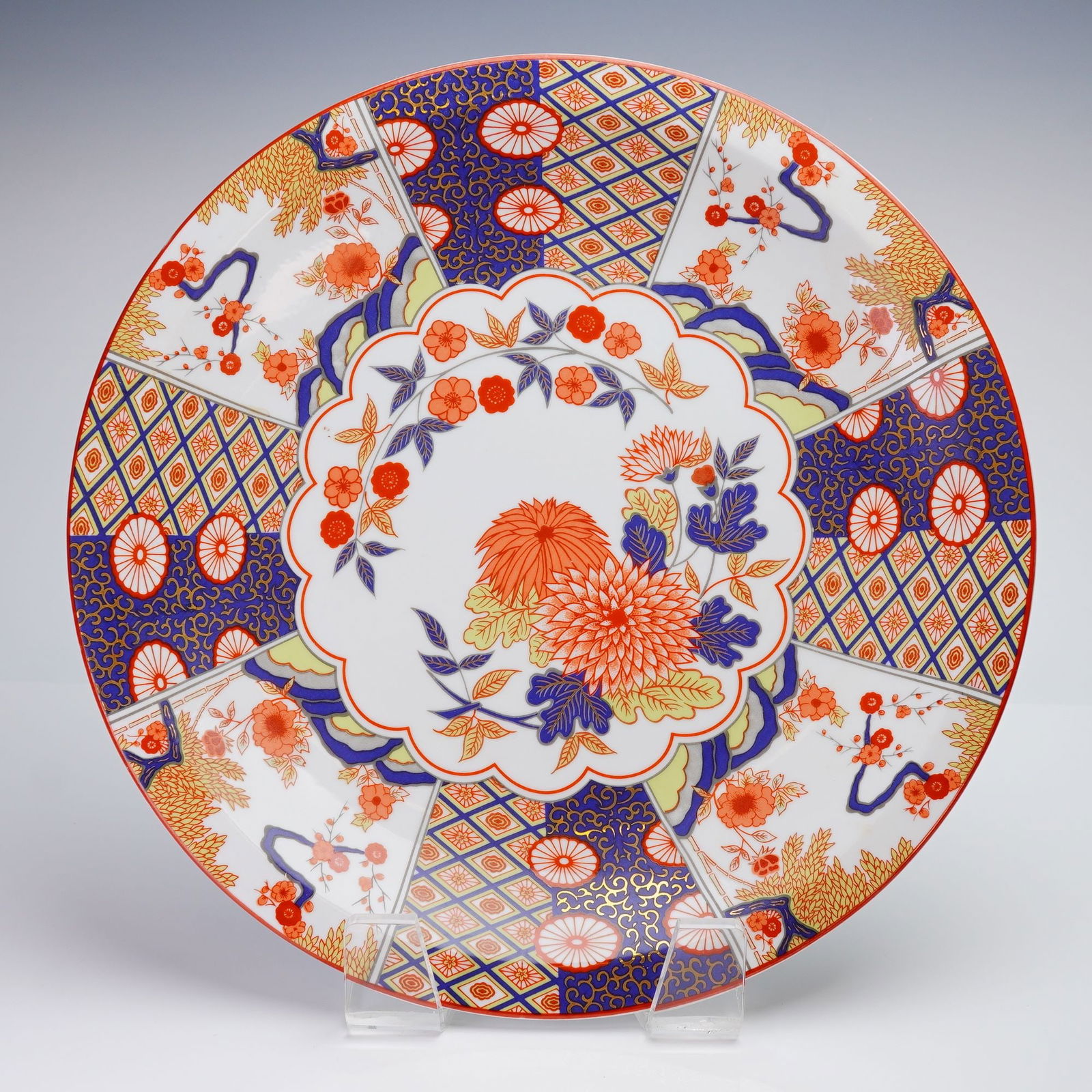 Decorative Porcelain Platter in Imari Chinoiserie Style: A decorative circular porcelain platter decorated with overglaze polychrome enamels and extensive gilding in a pattern evoking the Japanese Imari Chinoiserie style. The design features alternating rad