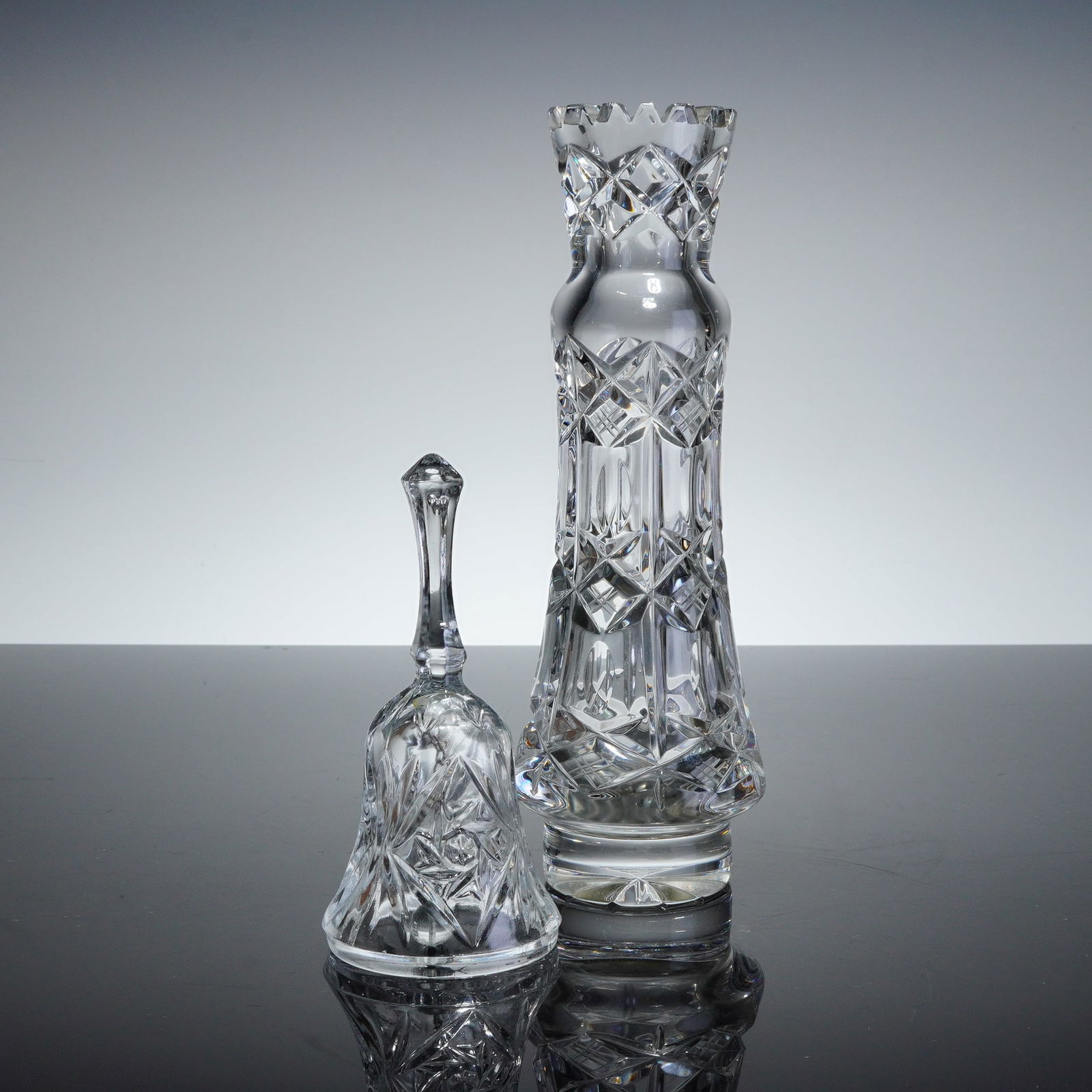 2pc Brilliant Cut Lead Crystal Vase and Handbell: A duo of decorative items comprised of one vase crafted from clear, heavy lead crystal and one accompanying glass handbell. The vase features extensive deep diamond-point cross-hatching across the