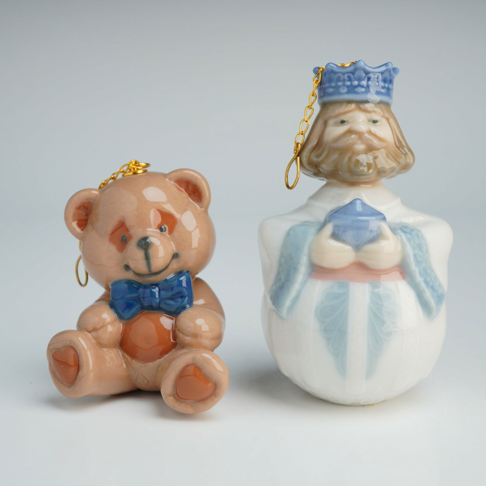 2pc Lladro Porcelain Christmas Ornaments, King Gaspar and Teddy Bear: A pair of Lladro glazed porcelain Christmas ornaments. The group includes a King Gaspar 1006380 figurine from the nativity series, depicted with a blue crown and holding a gift, and a Teddy Bear