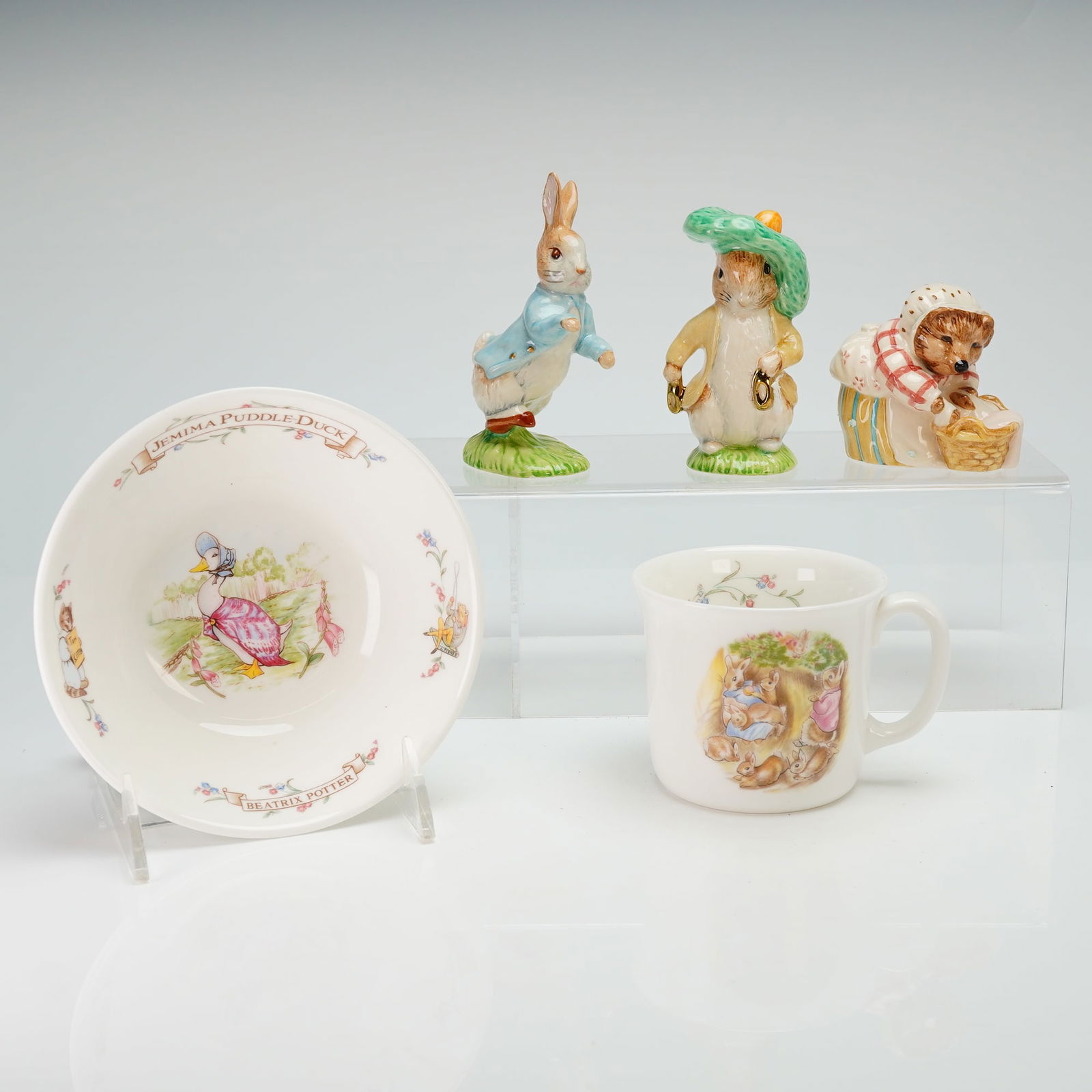 5pc Royal Albert Beatrix Potter Tableware & Beswick Ware Figurines: The hand-painted ceramic figurines include Peter Rabbit, Mrs. Tiggy-Winkle washing, and Benjamin Bunny with gold accents. Each figurine is marked Beswick England on the base. The nursery ware consists