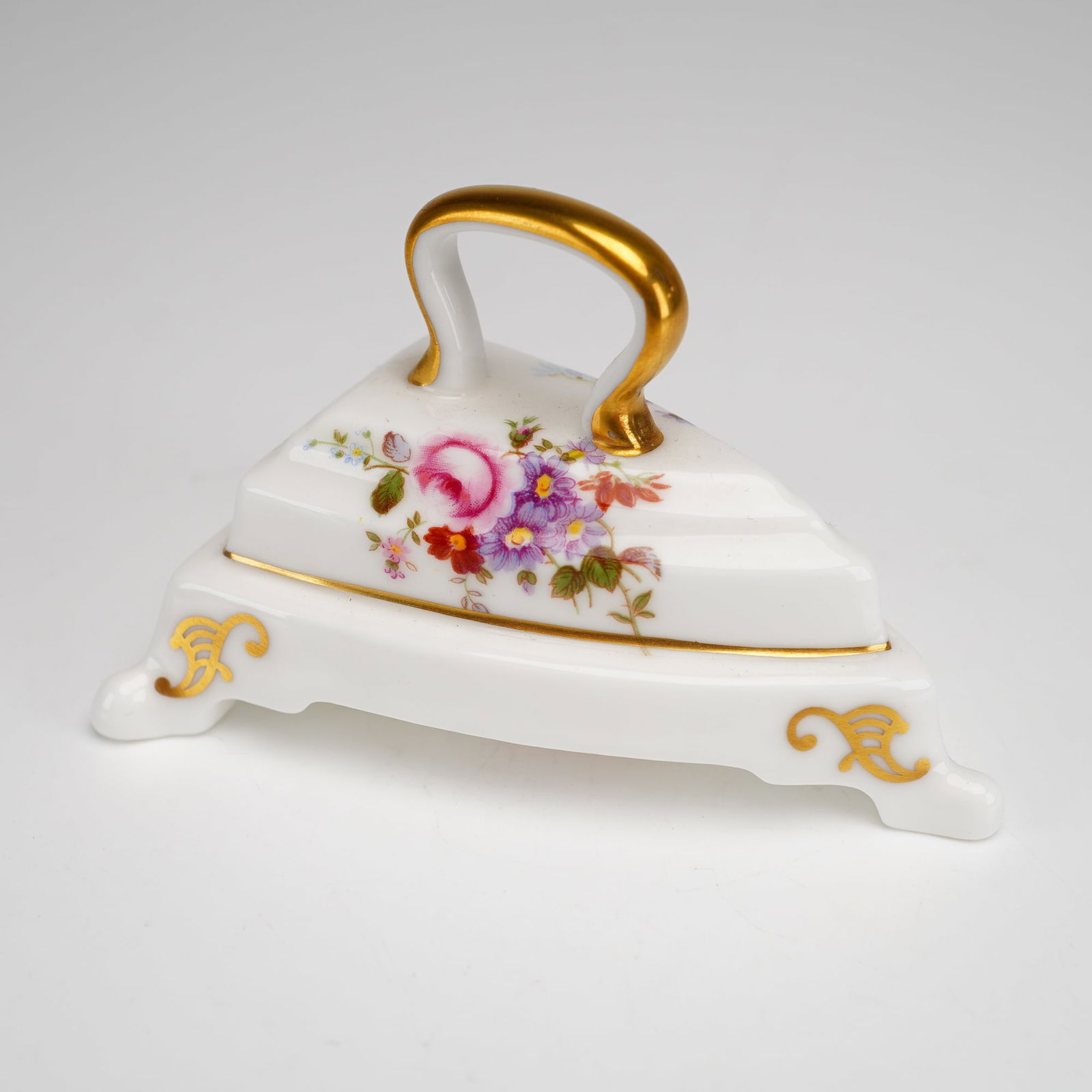 Royal Crown Derby Bone China Miniature, Derby Posies Iron & Stand: This miniature is decorated in the Derby Posies pattern, featuring polychrome floral sprays. Hand-applied gilt accents are present on the handle, the base rim of the iron, and the scrolled feet of