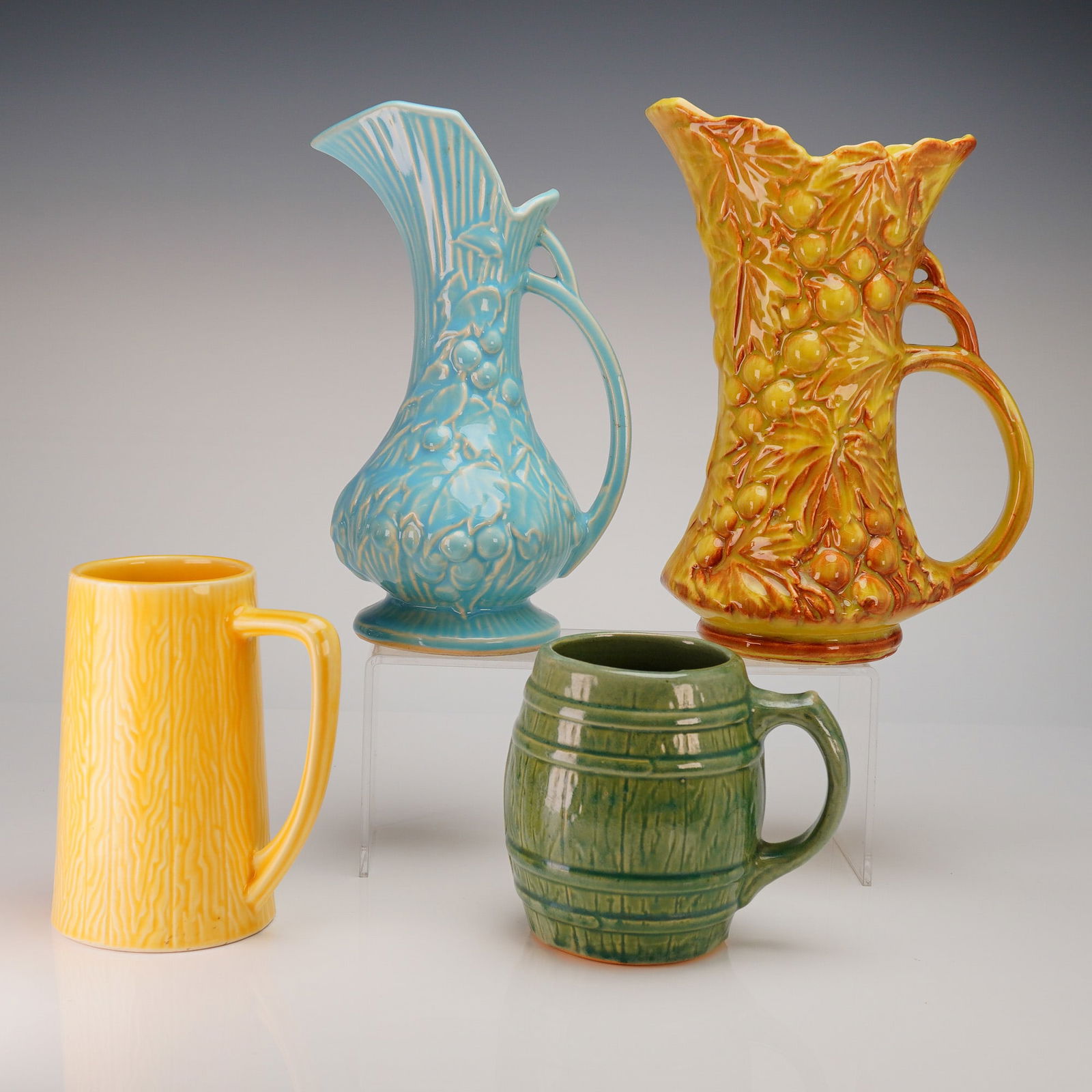 4 American Art Pottery, McCoy & Mount Clemens: A collection of four pieces (4pc) of Mid-20th Century American glazed ceramic art pottery, comprising two ewers, one stein, and one mug. The two taller pieces are ewers (pitchers/vases) in the Grape L