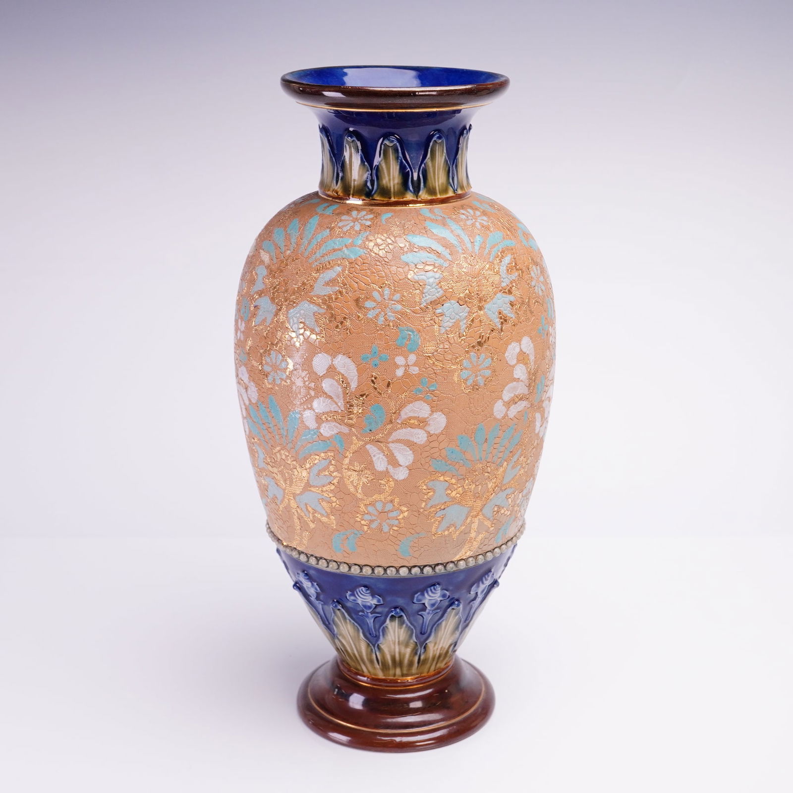 Royal Doulton Chine Gilt Ware Stoneware Vase: Early 20th century, featuring a netted lace textured ground with hand-painted blue, white, and gilt floral decoration. The neck and base in brown, blue, and green with Art Nouveau floral and foliage m