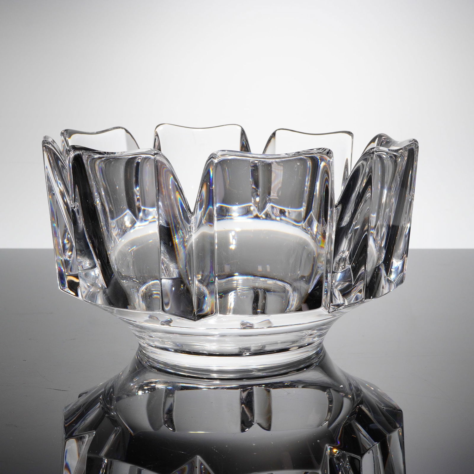 Orrefors Crystal Corona Bowl by Lars Hellsten: A single Orrefors Crystal bowl in the 'Corona' patern, designed by Lars Hellsten. The heavy, colorless lead crystal bowl features a highly geometric, faceted design characterized by sharp, angular cut