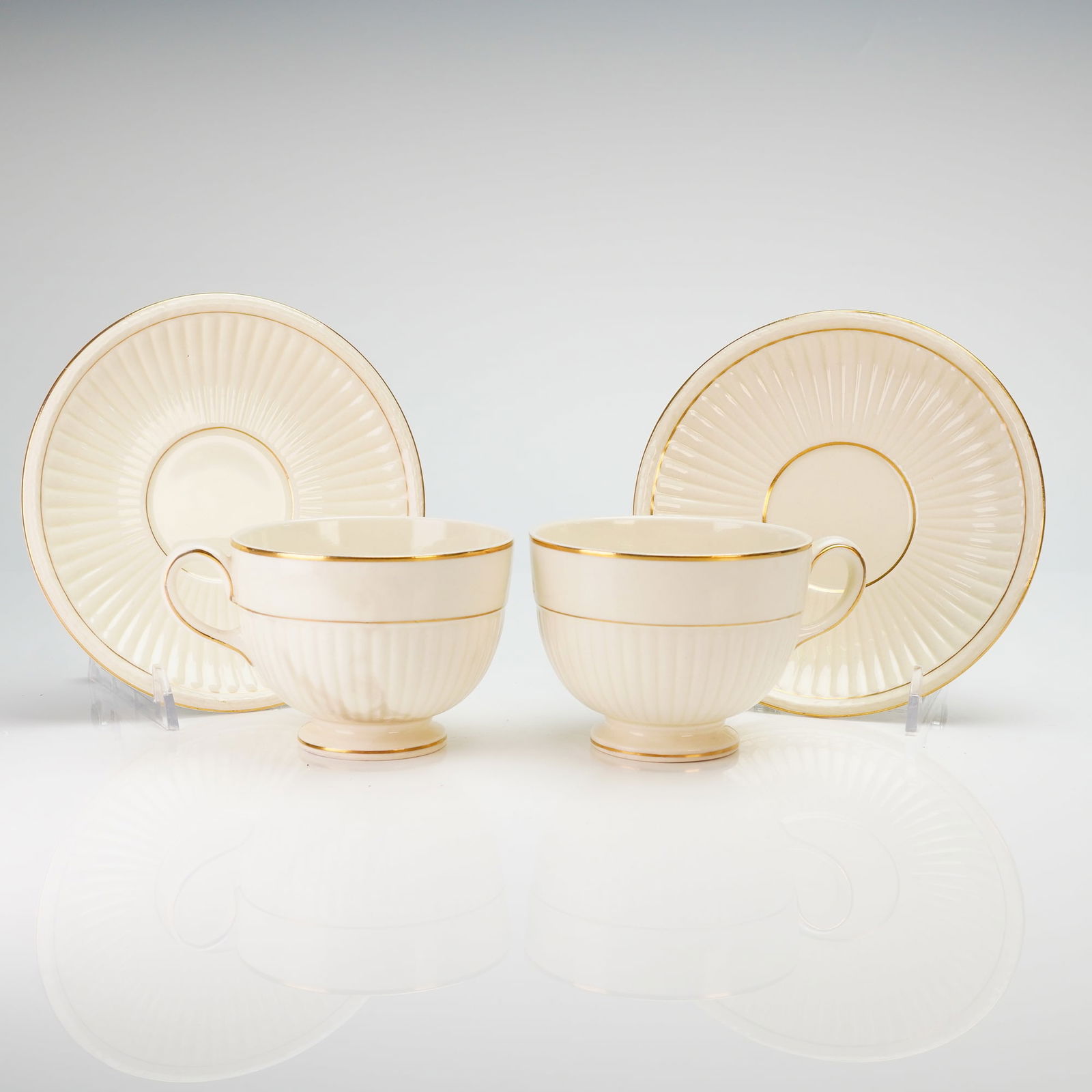 4pc Wedgwood & Barlaston of Etruria Cup and Saucer Sets, Edme: A collection of four Wedgwood Edme pattern creamware coffee cup and saucer sets. Each piece is constructed from cream-colored glazed ceramic featuring a traditional radial fluted or ribbed design on t