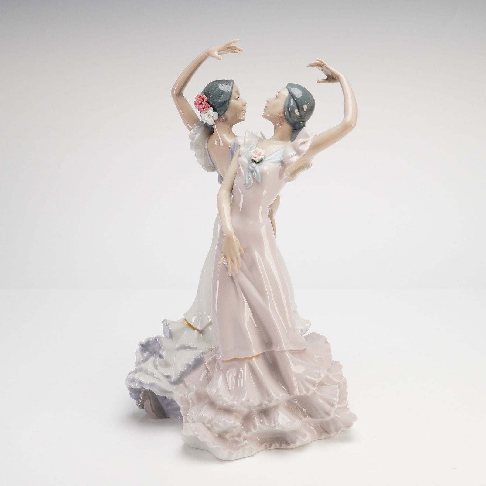 Lladro, Ole Flamenco Dancers Figurine: This Lladro glossy figurine model 5601, titled Ole, depicts two female Spanish dancers in traditional ruffled gowns. The figures are captured in a dynamic, expressive dance pose with arms raised and f