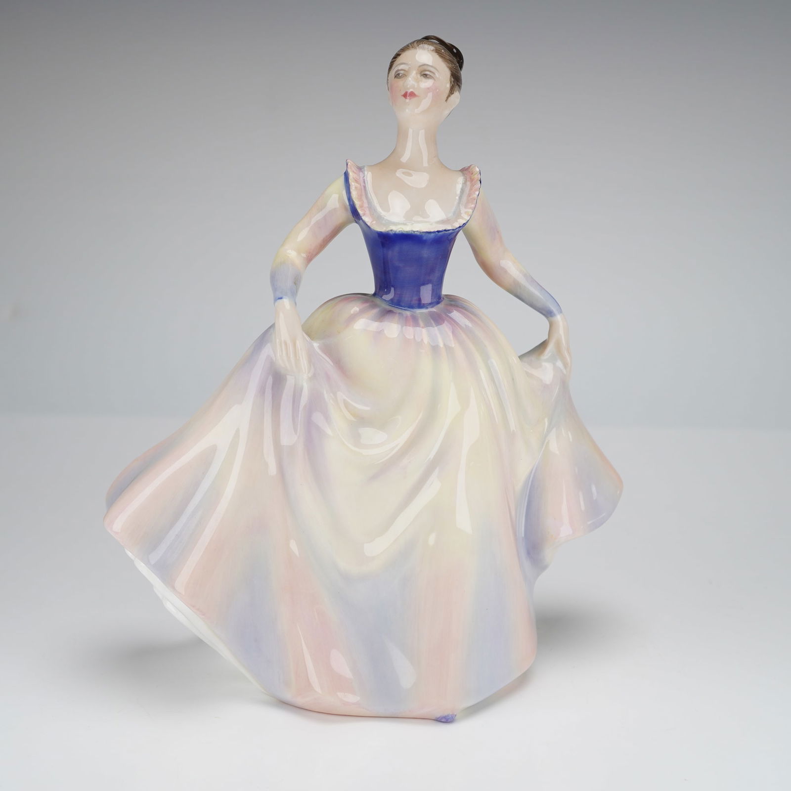 Royal Doulton Figurine Lisa HN2394: A single glazed bone china figurine by Royal Doulton, titled "Lisa." The figure depicts a standing female dancer or lady in a voluminous, flowing dress. The piece is hand-painted, featuring a dark