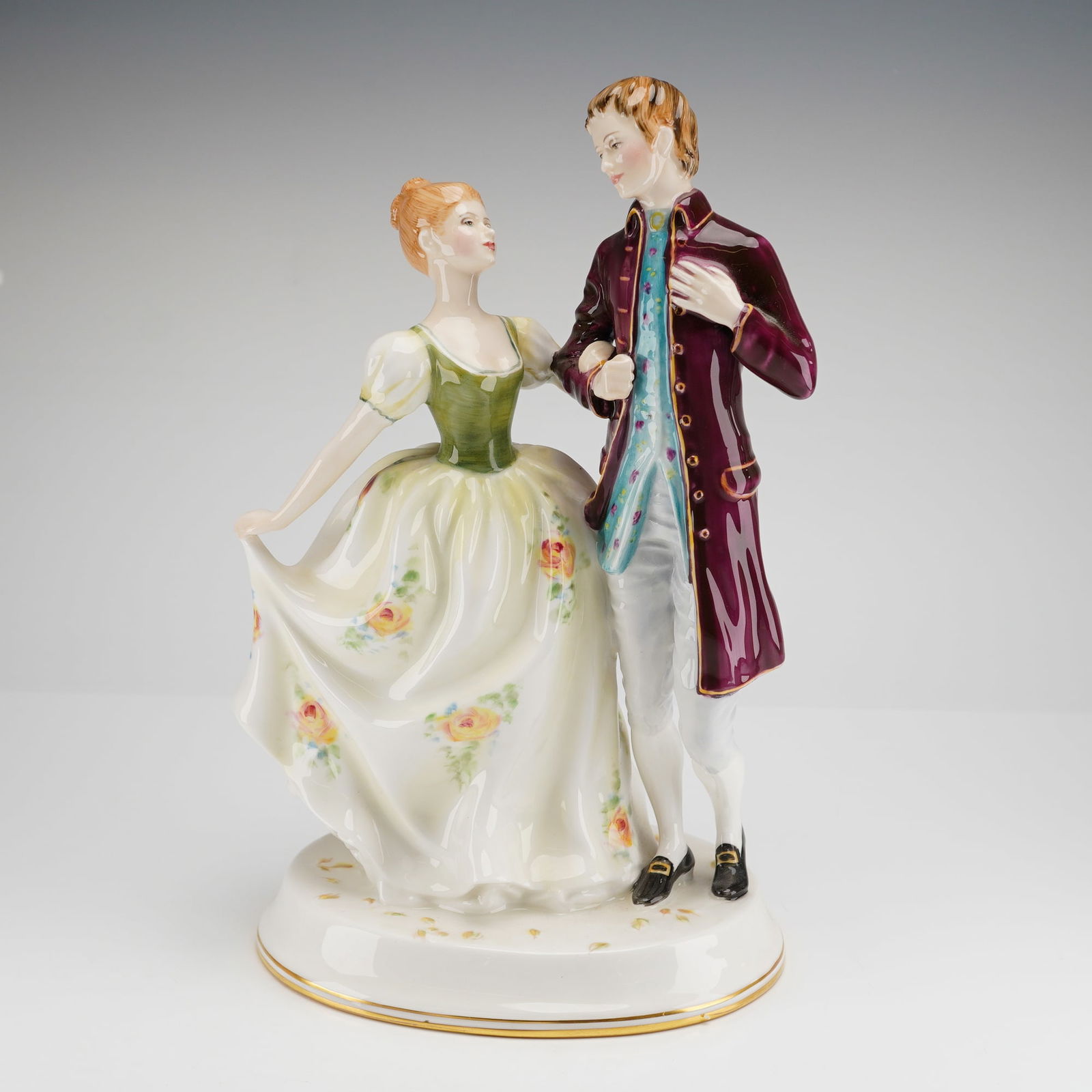 Young Love HN2735 Royal Doulton Figurine: A Royal Doulton bone china figurine titled Young Love, model number HN 2735. This hand-painted porcelain piece depicts a couple in stylized 18th-century attire. The male figure is shown in a plum-colo