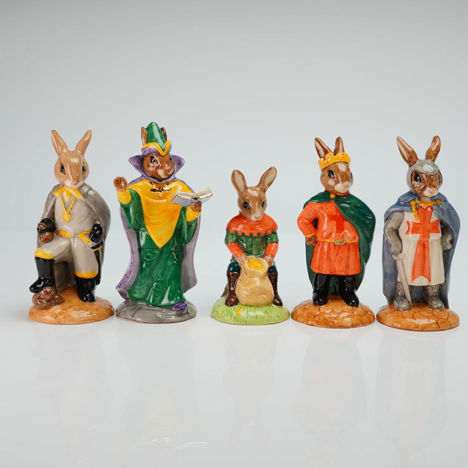Five Royal Doulton Bunnykins Figurines: A set of five Royal Doulton Bunnykins figurines, comprising pieces from The Robin Hood Collection and the Millennium Collection. The group includes the following hand-decorated ceramic figures: King R