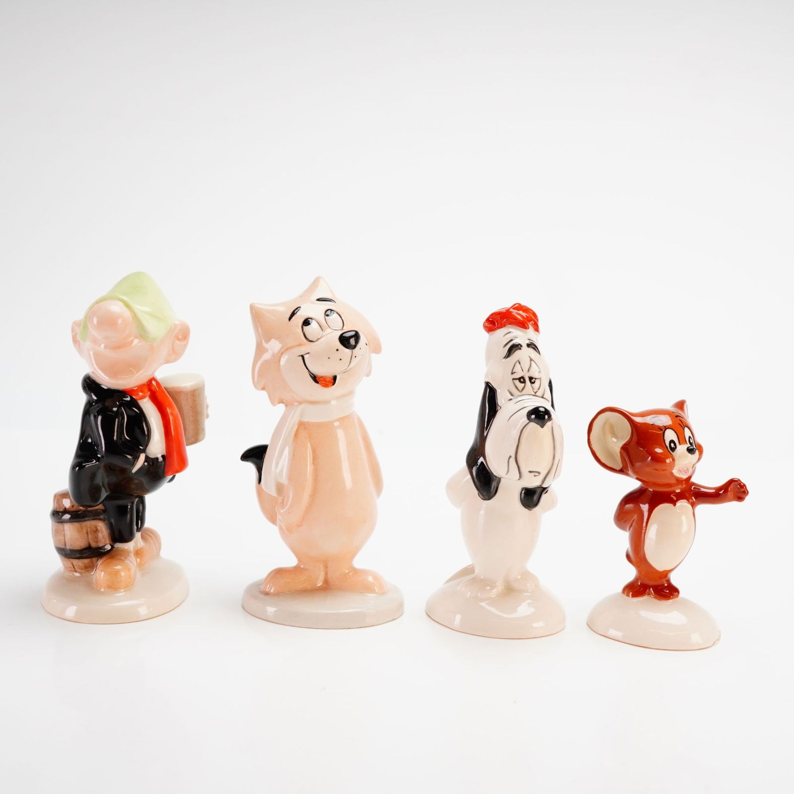 Royal Doulton and John Beswick Limited Edition Cartoon Character Figurines: This collection features four limited edition glazed ceramic figurines produced by Royal Doulton and John Beswick. The set includes the character Andy Capp (model HN AC), depicted in his signature fla