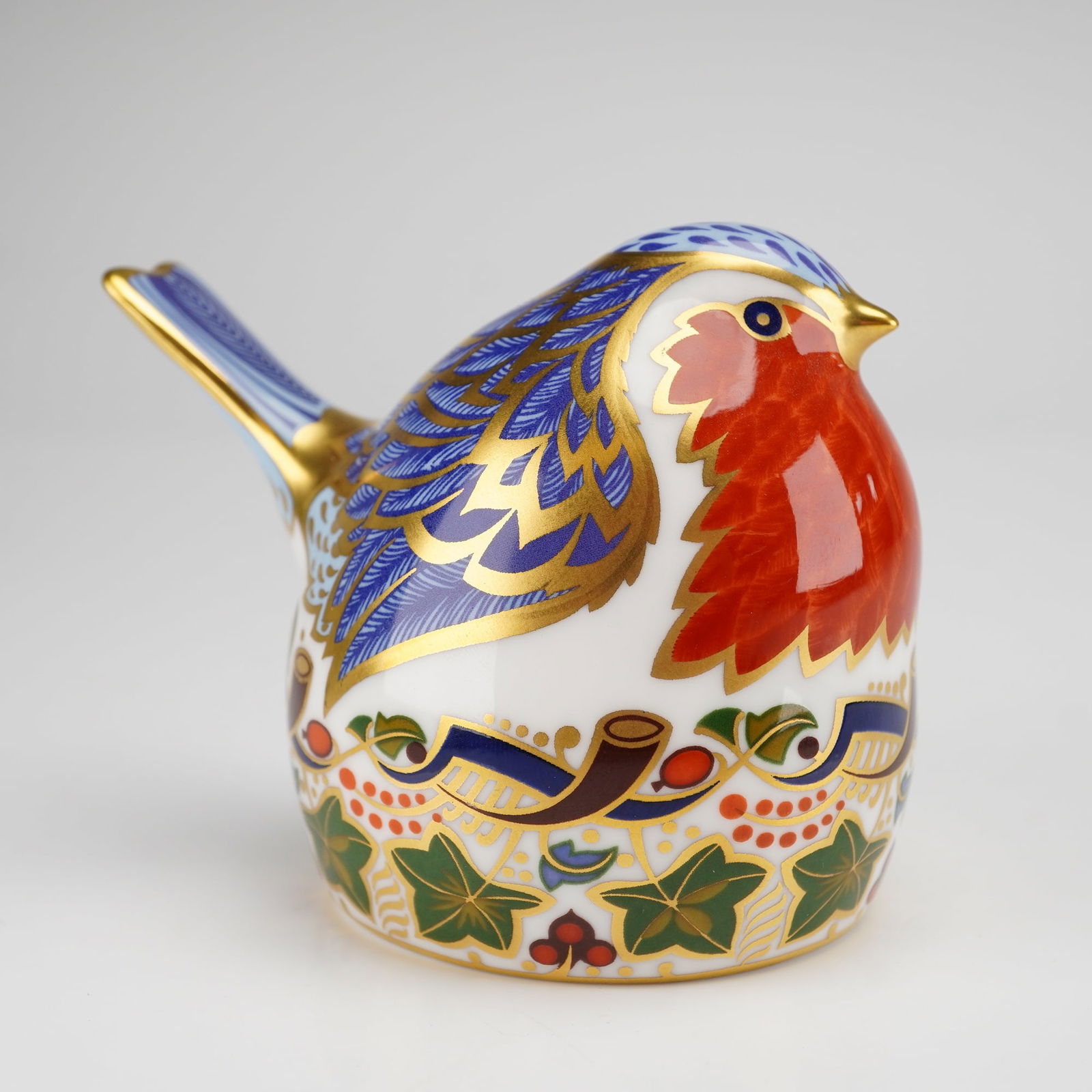 Royal Crown Derby Bone China Robin Nesting Finch Paperweight: Royal Crown Derby fine bone china paperweight titled Robin Nesting, modeled as a finch-type bird with Imari decoration. The piece is decorated in a palette of cobalt blue, iron red, and green, with go