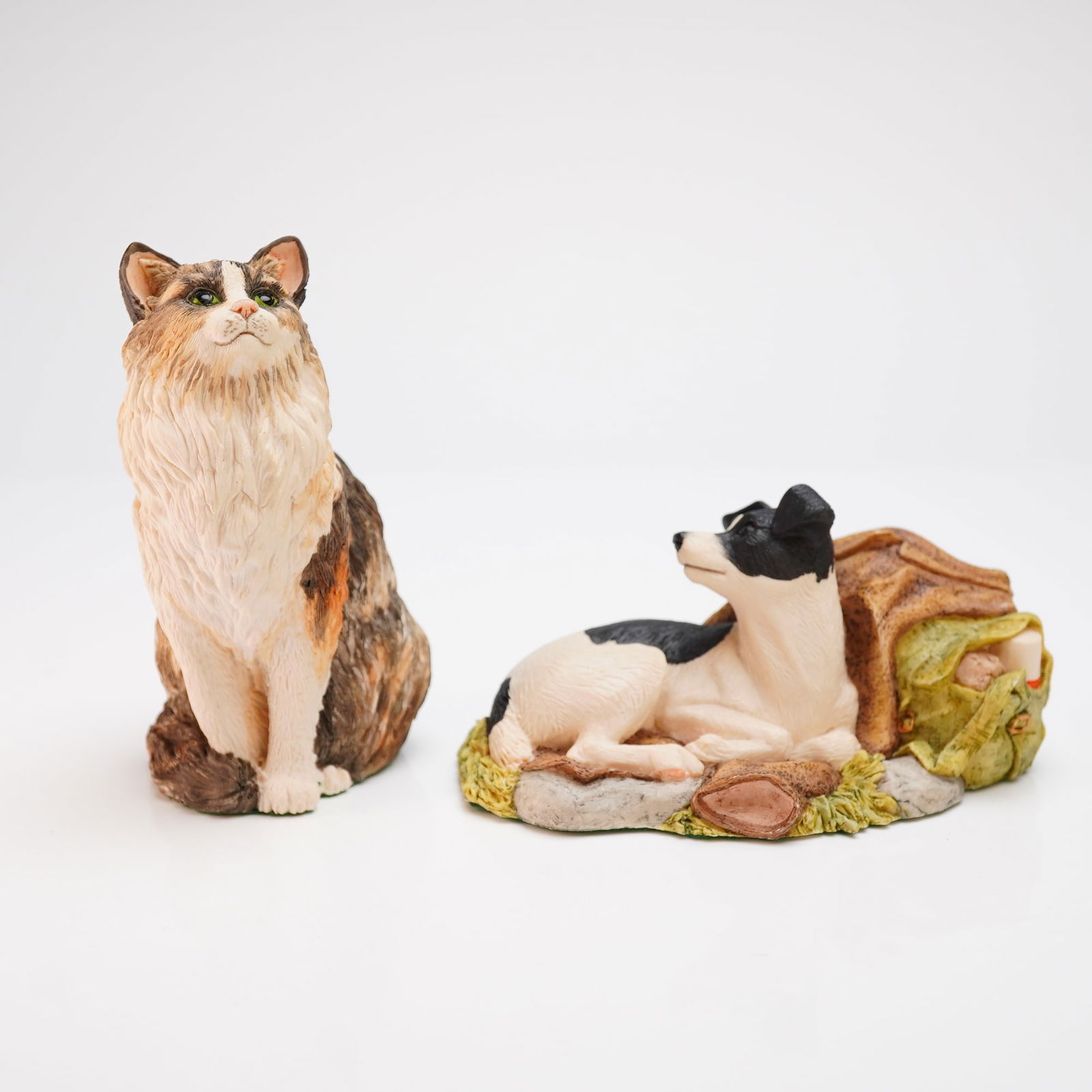 2pc Border Fine Arts Scotland Animal Figurines: Two Border Fine Arts animal figurines handmade in Scotland. The lot consists of a Jack Russell Terrier and a long-haired calico cat. The Jack Russell Terrier, identified as model 208B, is depicted in