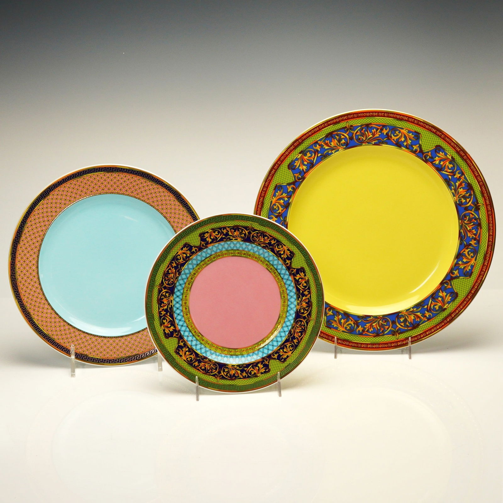 3pc Versace Rosenthal Porcelain Plate Set, Russian Dream: This porcelain plate set includes a 10.5" dinner plate, a 8.75" salad plate, and a 7.25" side plate. Each piece features a color palette of yellow, pink, turquoise, and lime green. The designs incorpo