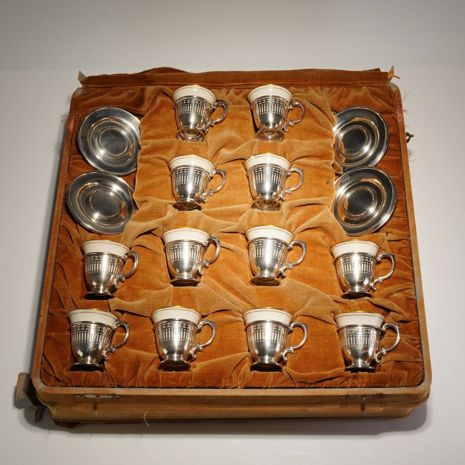 36pc Sterling Silver and Lenox Porcelain Demitasse Cup and Saucer Set: Set of 12 Lenox porcelain demitasse cups with 12 sterling silver holders and 12 sterling silver saucers. The demitasse cups feature a gilt rim and are marked with the green Lenox wreath mark on the un