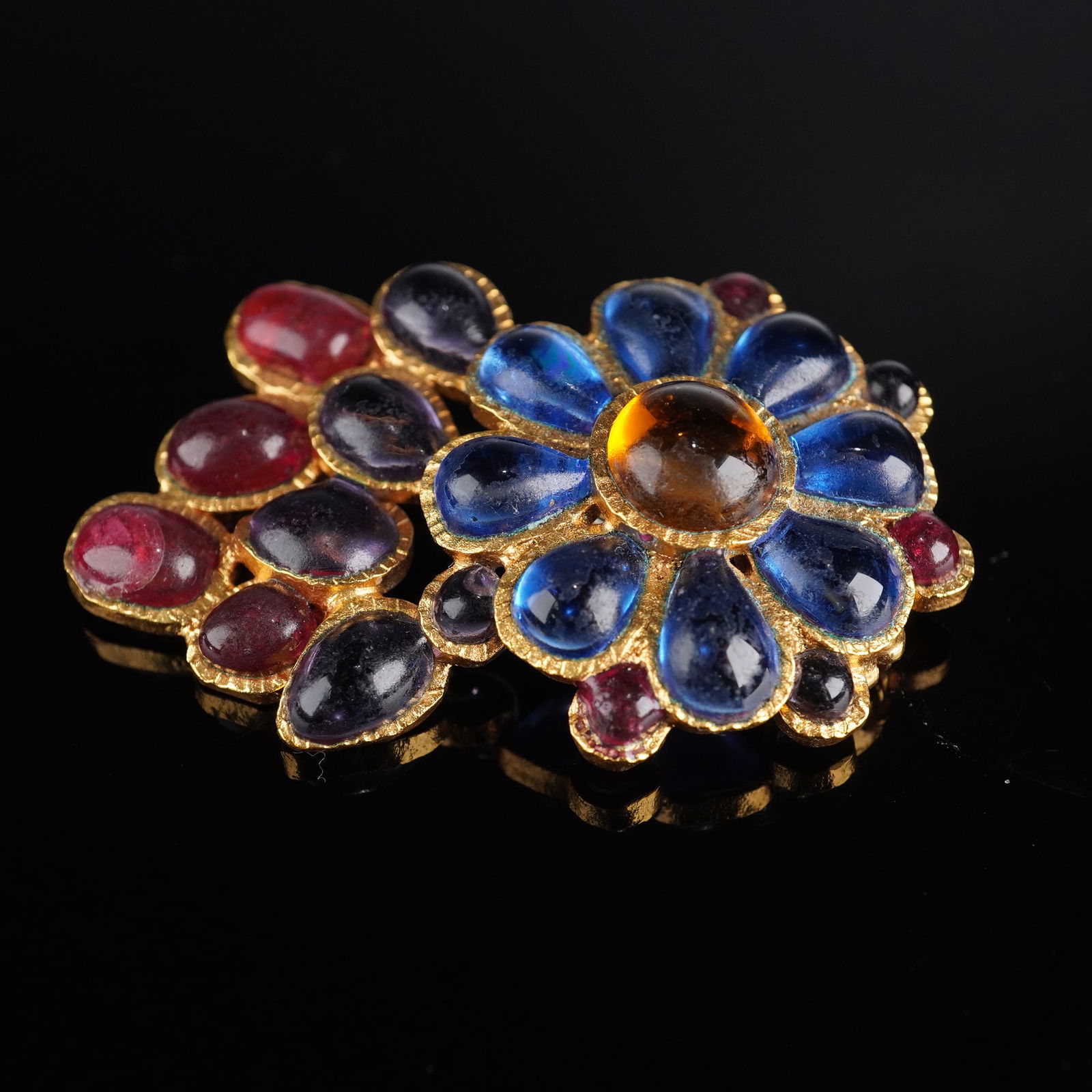 Chanel Gold-Tone Floral Brooch with Multicolor Gripoix Cabochons: A CHANEL gold-toned floral-foliate cluster brooch, adorned with numerous irregularly shaped, smooth cabochon-cut elements in various sizes and colors, including blue, deep red, purple, and a central a