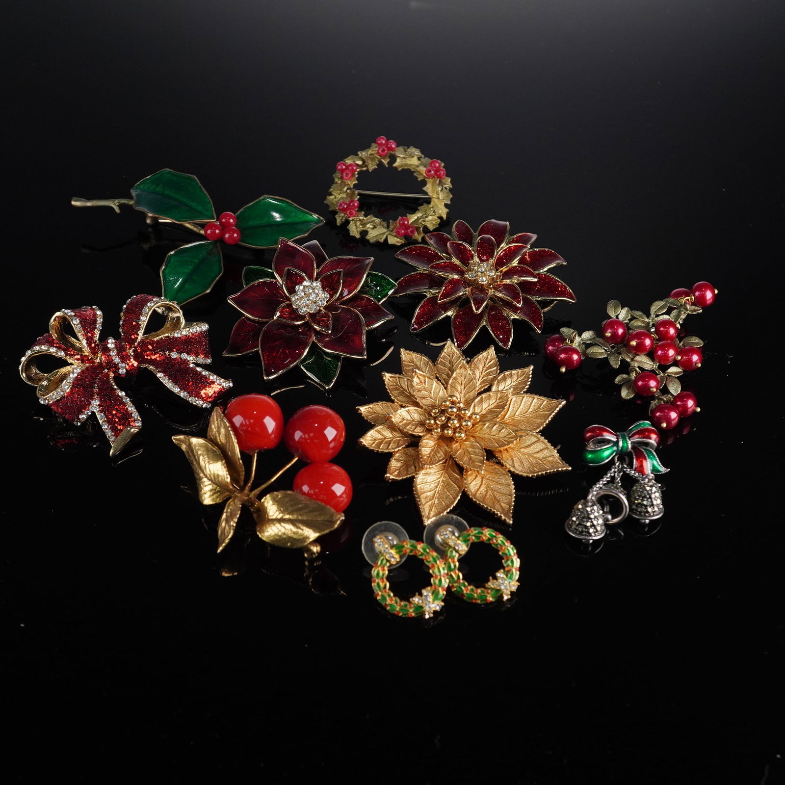 11pc Holiday-Themed Brooches and Earrings: This lot of costume jewelry consists of nine brooches and one pair of earrings, all designed with a festive holiday theme. The items are crafted from gold-tone metal and feature various accents