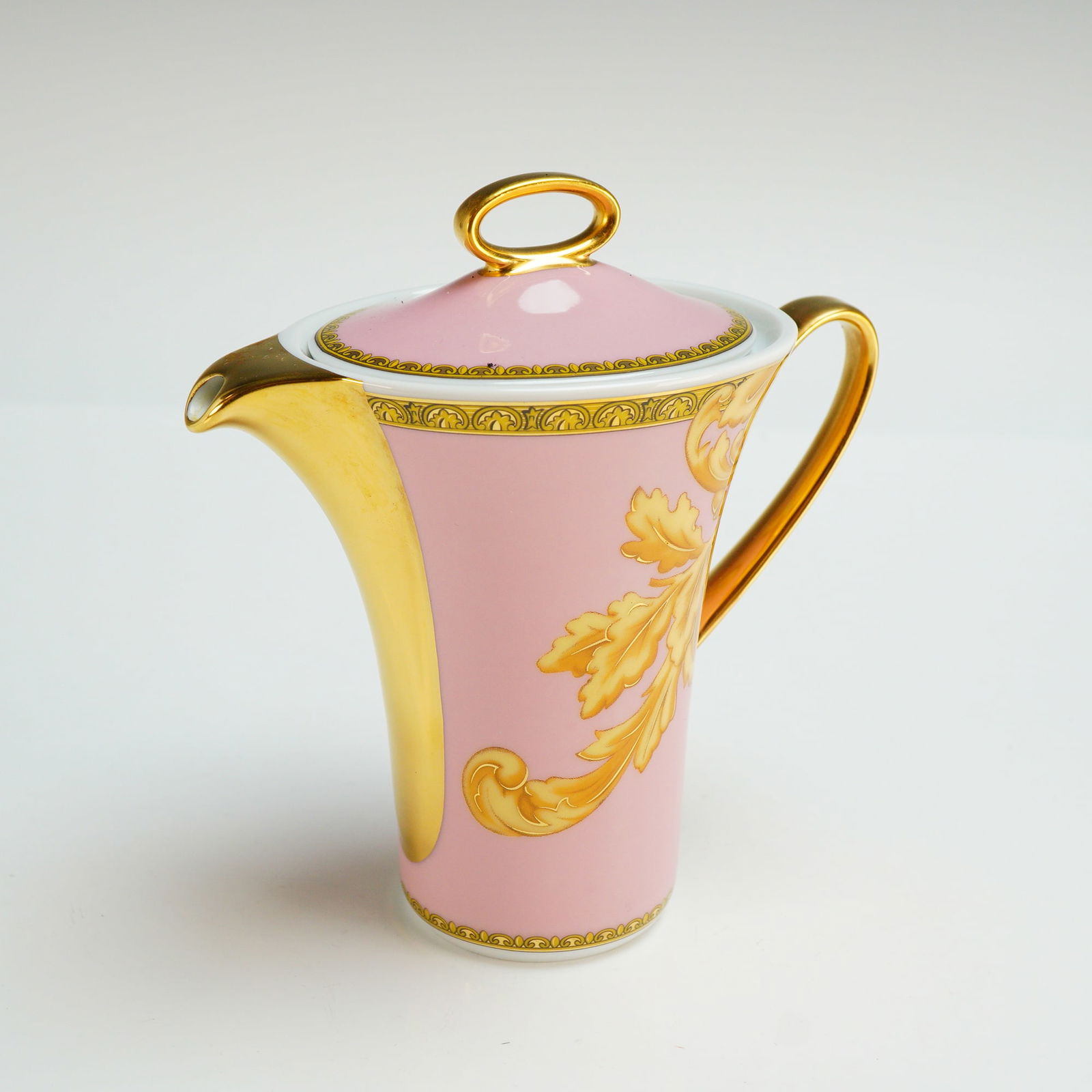 Versace Rosenthal Porcelain Lidded Creamer, Les Reves Byzantins: The vessel features a pink ground decorated with gold-gilded acanthus leaf scrolls and ornate geometric borders. The design includes a fully gilded spout and handle. The matching lid is topped with a